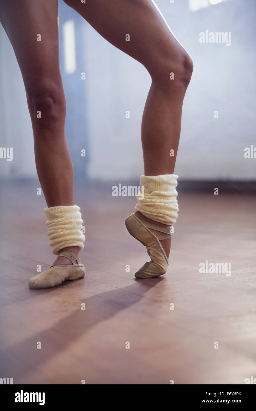 Danseur de Ballet s'étendant les orteils dans un studio de danse Banque D'Images