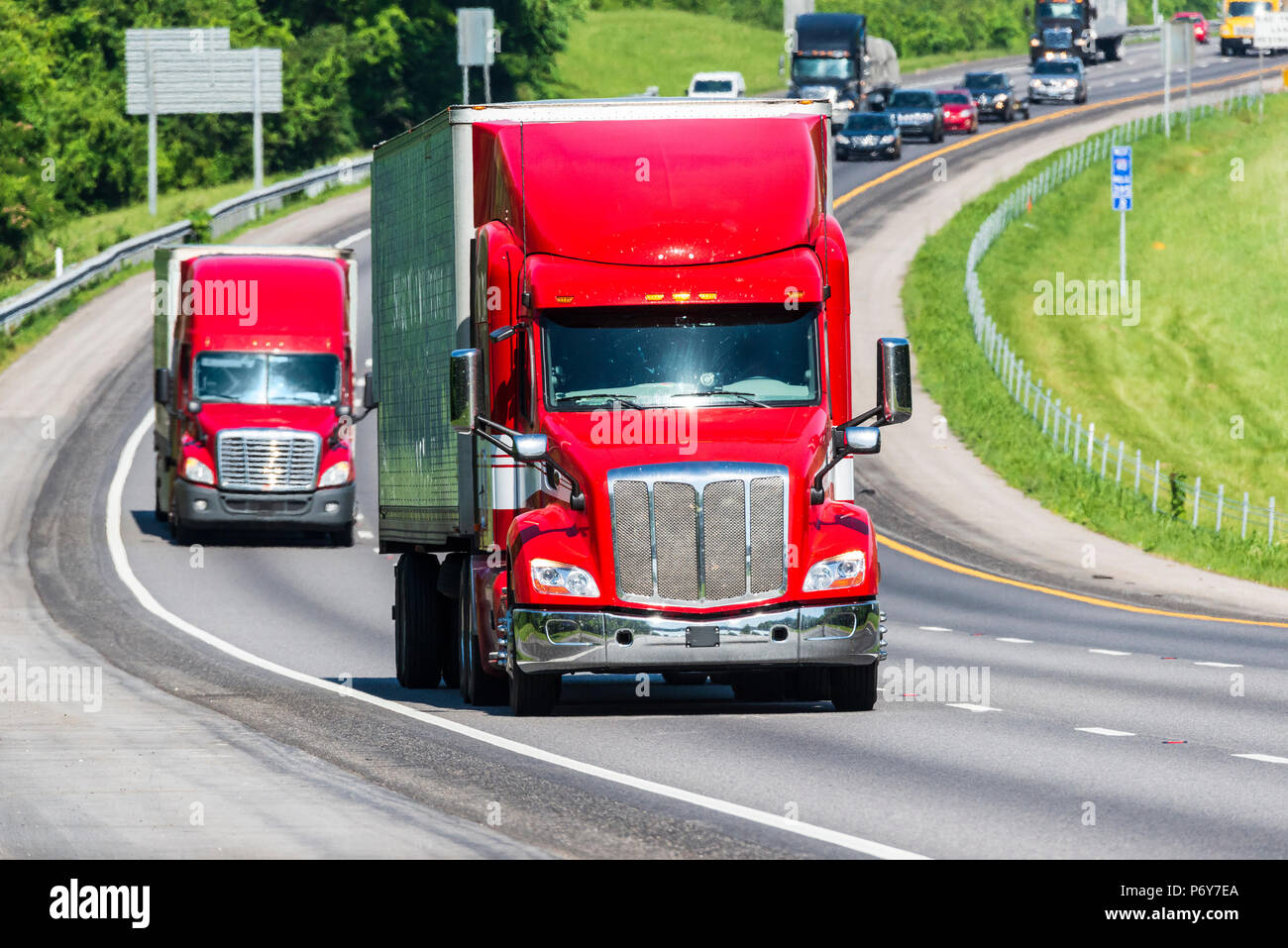 Deux camions rouge sur un Indiana interstate. Capture d'image sur chaude journée. Les vagues de chaleur de l'asphalte créer de distorsion, en particulier sur les véhicules plus loin de la c Banque D'Images