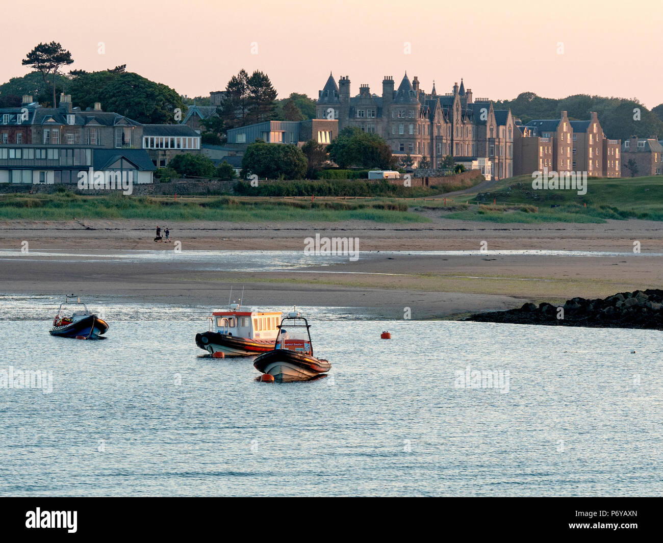 Avec les bateaux de l'hôtel Macdonald Marine dans l'arrière-plan au coucher du soleil de North Berwick Harbour, East Lothian, Ecosse, Royaume-Uni Banque D'Images