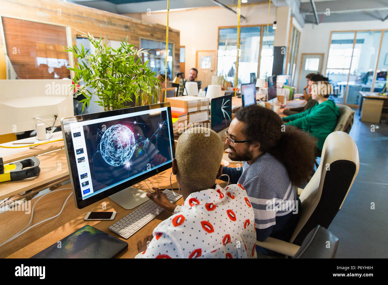 Les graphistes travaillant dans open plan office Banque D'Images