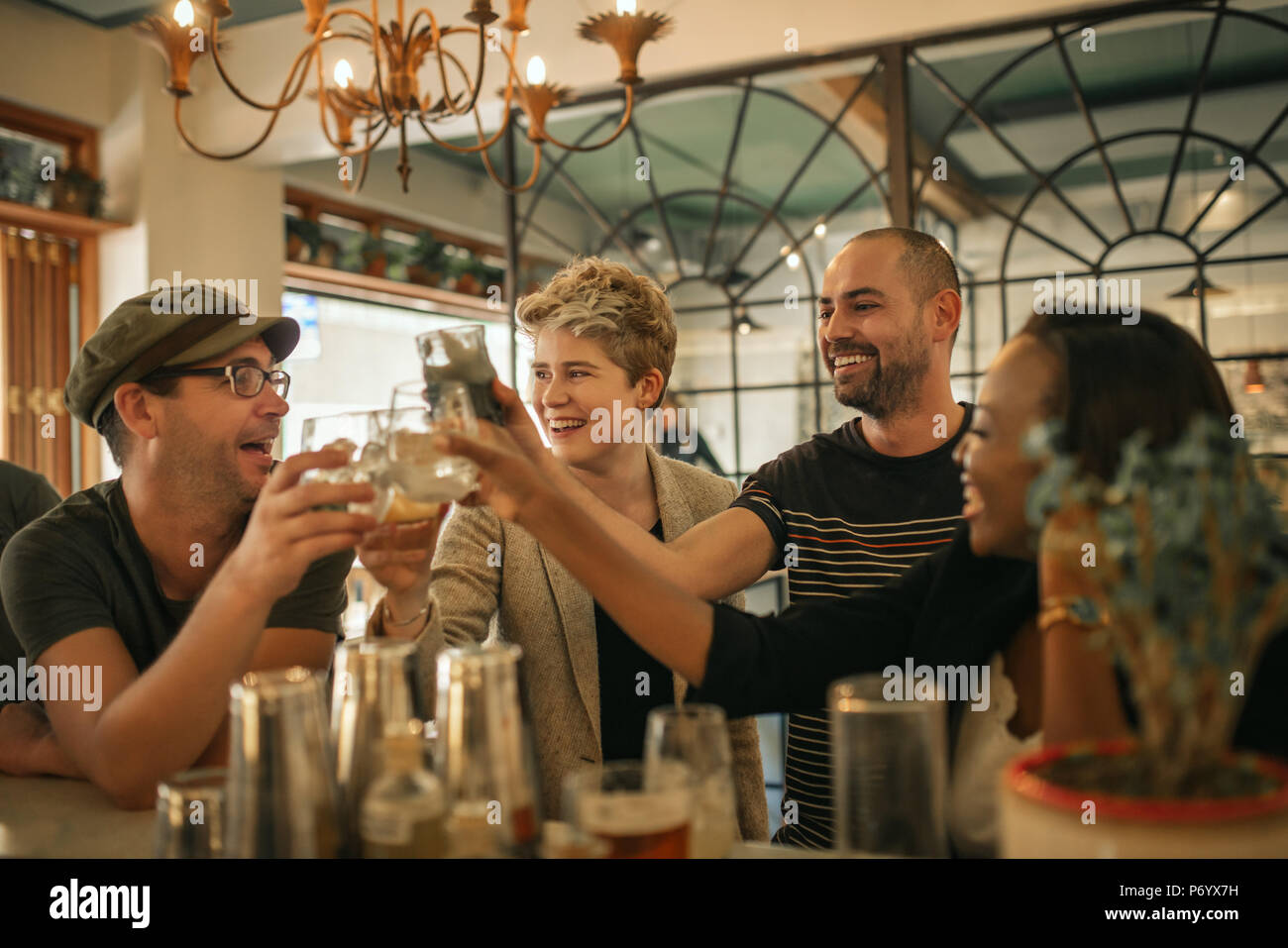 Groupe d'amis avec acclamations des boissons dans un bar branché Banque D'Images