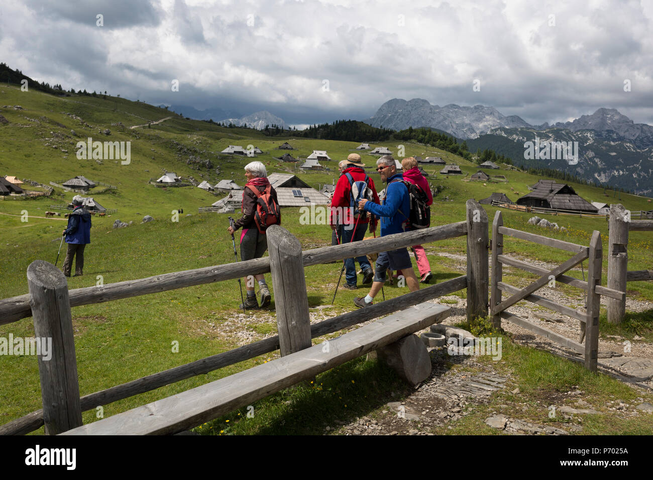 Les promeneurs quittent la chapelle dédiée à Notre Dame des Neiges, construite en 1938 par l'architecte slovène Jože Plečnik, au-dessus de la collection de cabanes de montagne des bergers slovène à Velika Planina, le 26 juin 2018, à Velika Planina, près de Kamnik, la Slovénie. Velika Planina est un plateau montagneux dans l'Kamnik Savinja-Alpes - une zone de 5,8 kilomètres carrés, 1 500 mètres (4 900 pieds) au-dessus du niveau de la mer. Autrement connu comme le grand plateau de pâturage, Velika Planina est une destination de ski en hiver et à vélo en été. Les huttes des bergers sont devenus populaires au début des années 1930 comme maison de cabines (connu comme bajtarstvo) Banque D'Images