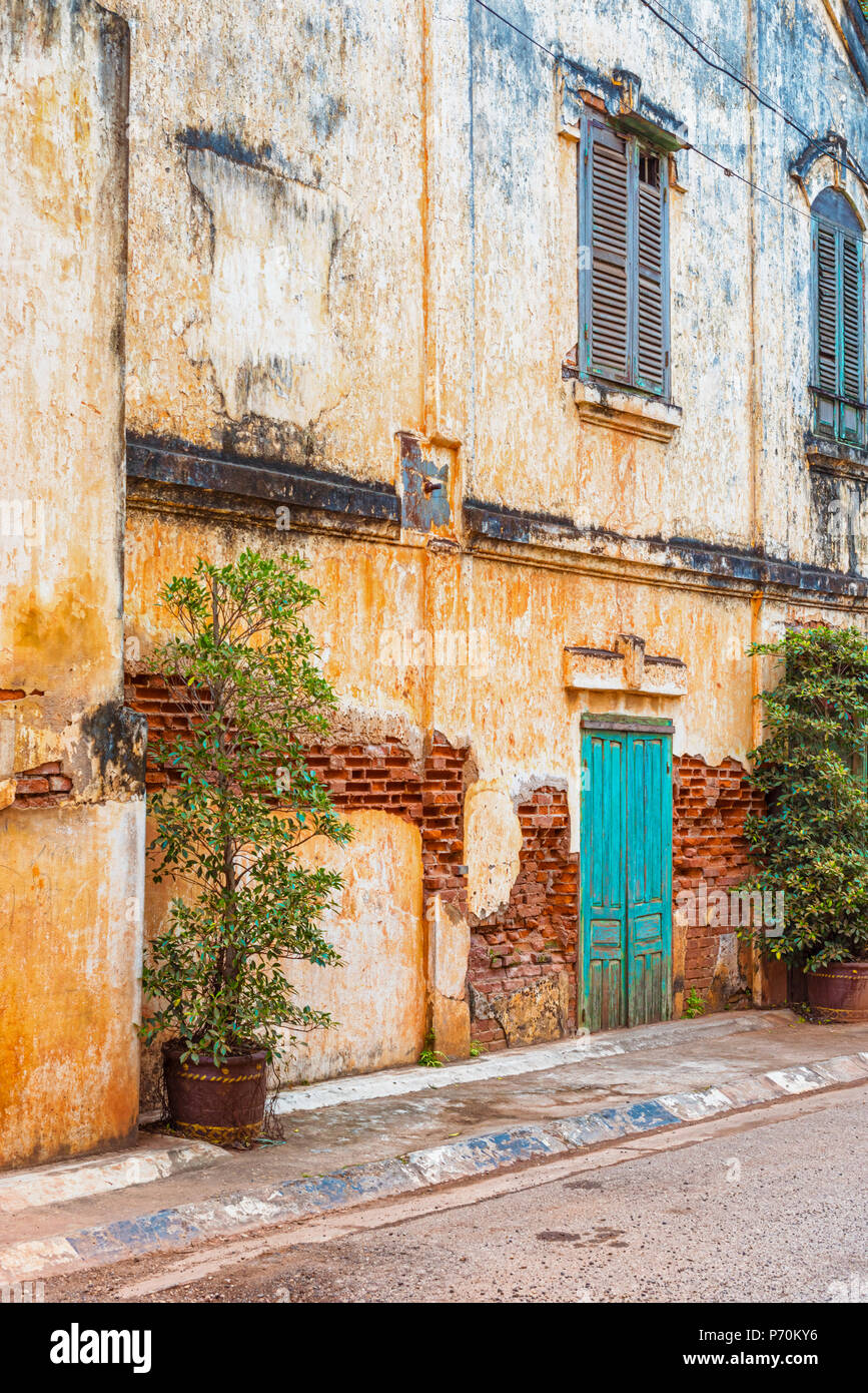 Ancien bâtiment colonial français avec la décoloration de la peinture écaillée et béton dans Savennakhet, Laos. Banque D'Images