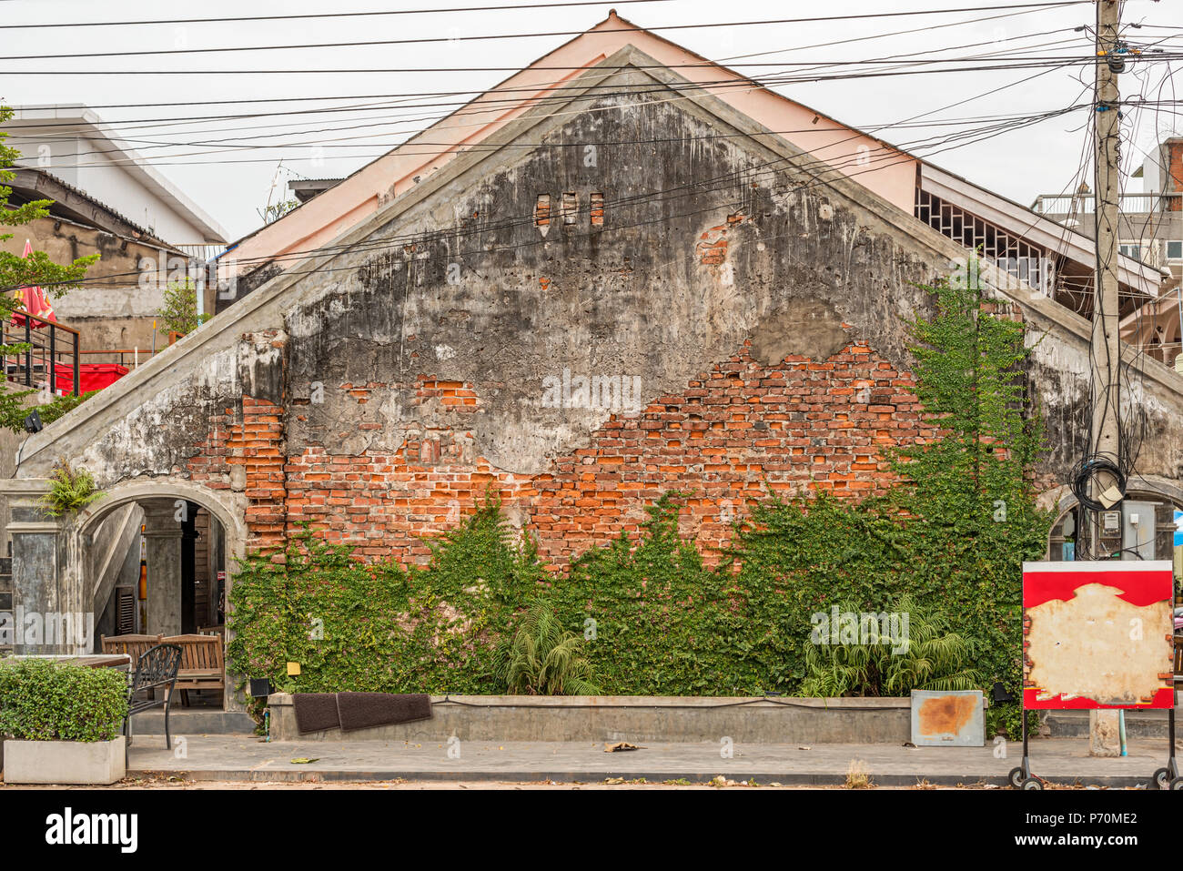 Ancien bâtiment colonial français avec la décoloration de la peinture écaillée et béton dans Savennakhet au Laos. Banque D'Images