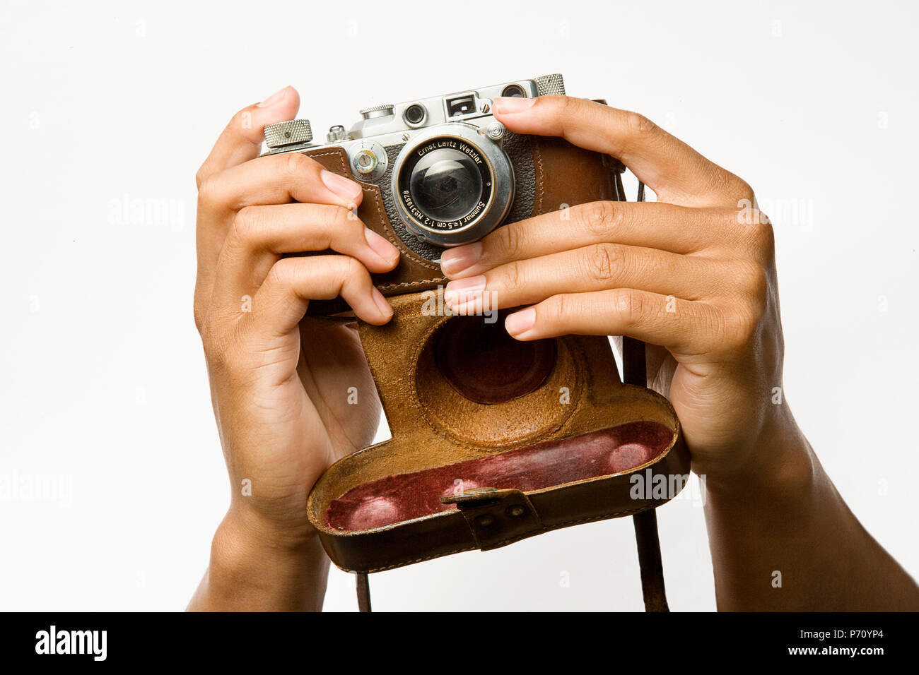 Vieux Leica Camera tenir par deux mains. Montage vis objectif 50 mm et un étui en cuir Banque D'Images