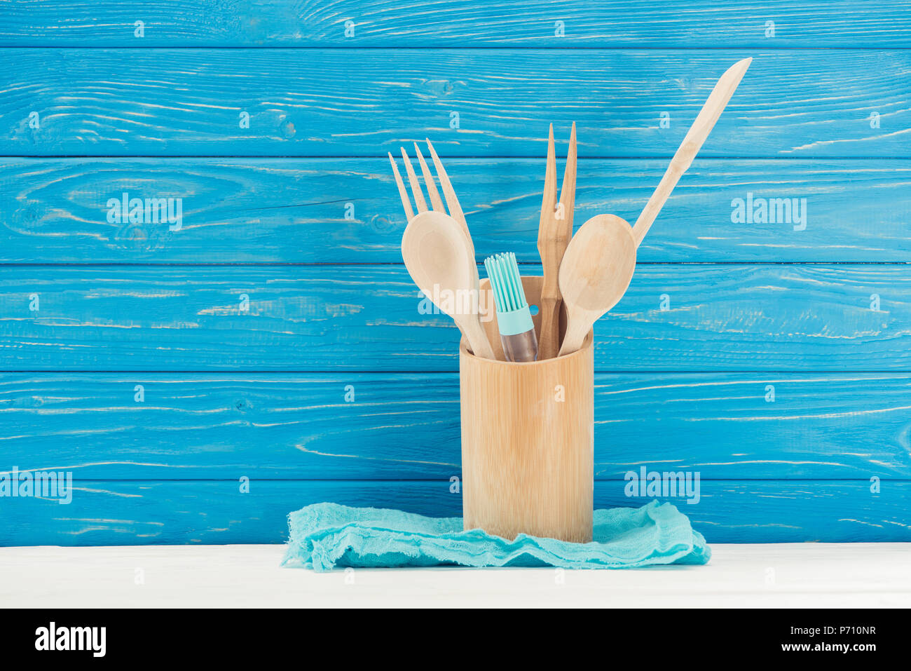 Vue rapprochée du chiffon, pinceau à pâtisserie et des ustensiles de cuisine en face du mur en bois bleu Banque D'Images