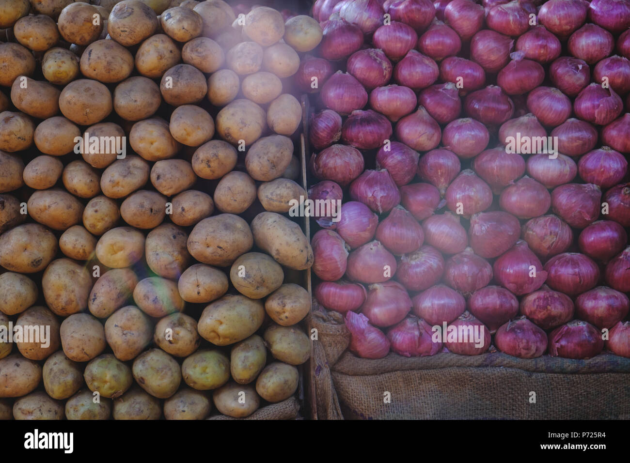 Oignons rouges frais et des pommes de terres basses en rangées sur légumes du marché Banque D'Images