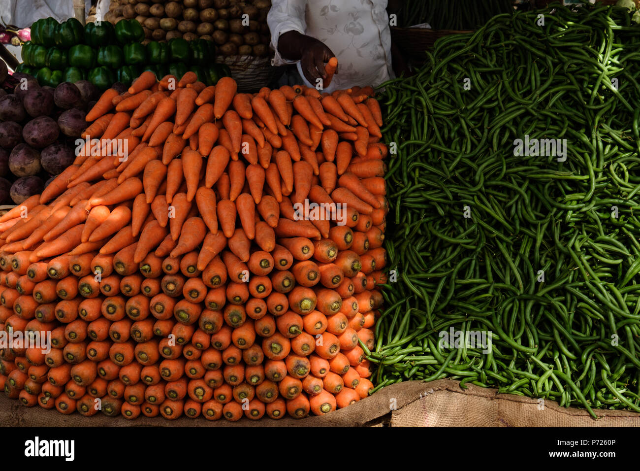 L'homme indien frais de vente des légumes sur le marché, carottes, cuccumber, paprika vert Banque D'Images