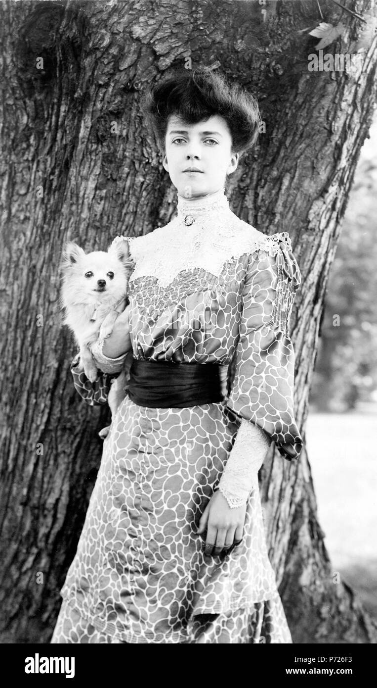 French : Photo de fr:Alice Roosevelt, fille du président américain Theodore Roosevelt fr:prise en 1902 avec son chien de compagnie, Leo. Elle a aussi donné le chien Manchu, un fr:mignon petit canard, lui a présenté par le fr:Impératrice douairière Cixi. Alice, avec sa beauté, d'esprit et attitude insouciante a été le centre de beaucoup d'attention des médias dans les premiers jours de l'Administration Roosevelt 'TR' Alice Roosevelt, prises à propos de 1902. Une beauté saisissante, son franc-parler et bouffonneries a gagné le cœur de l'Amérique des gens qui la surnomme "la princesse Alice' . 19021 AliceRooseveltwPekingeseDog1902 Banque D'Images