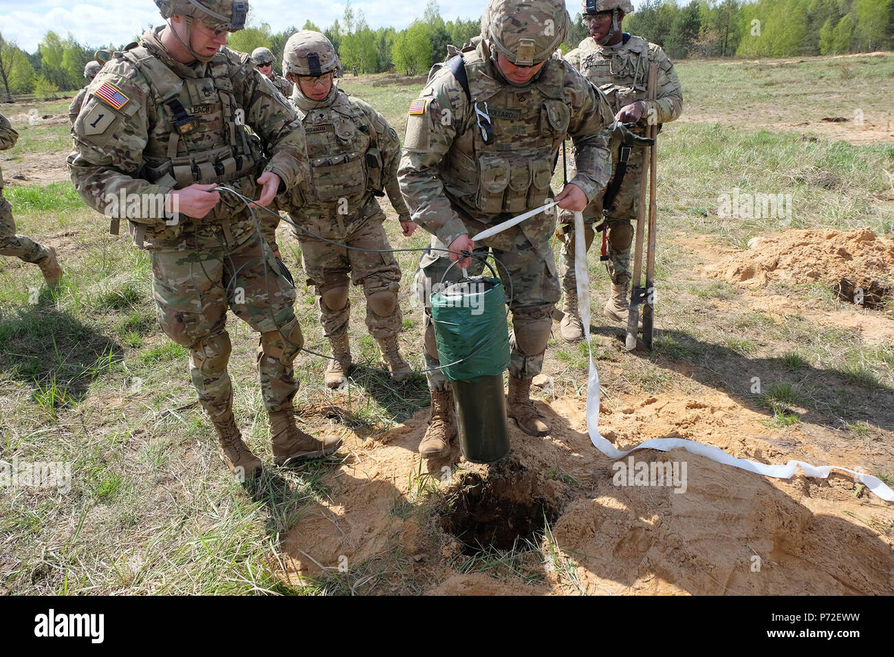 Pologne Groupe bataille Soldat PFC. Kyle Pollard commence la descente d'une charge de cratères dans un trou de tir réel au cours de la formation de démolition près de Bemowo Piskie Domaine de formation, la Pologne, le 10 mai. L'interopérabilité formation a aidé les États-Unis et le Royaume-Uni l'ingénierie groupe de combat des soldats effectuent des missions de démolition dans un environnement mixte. Banque D'Images