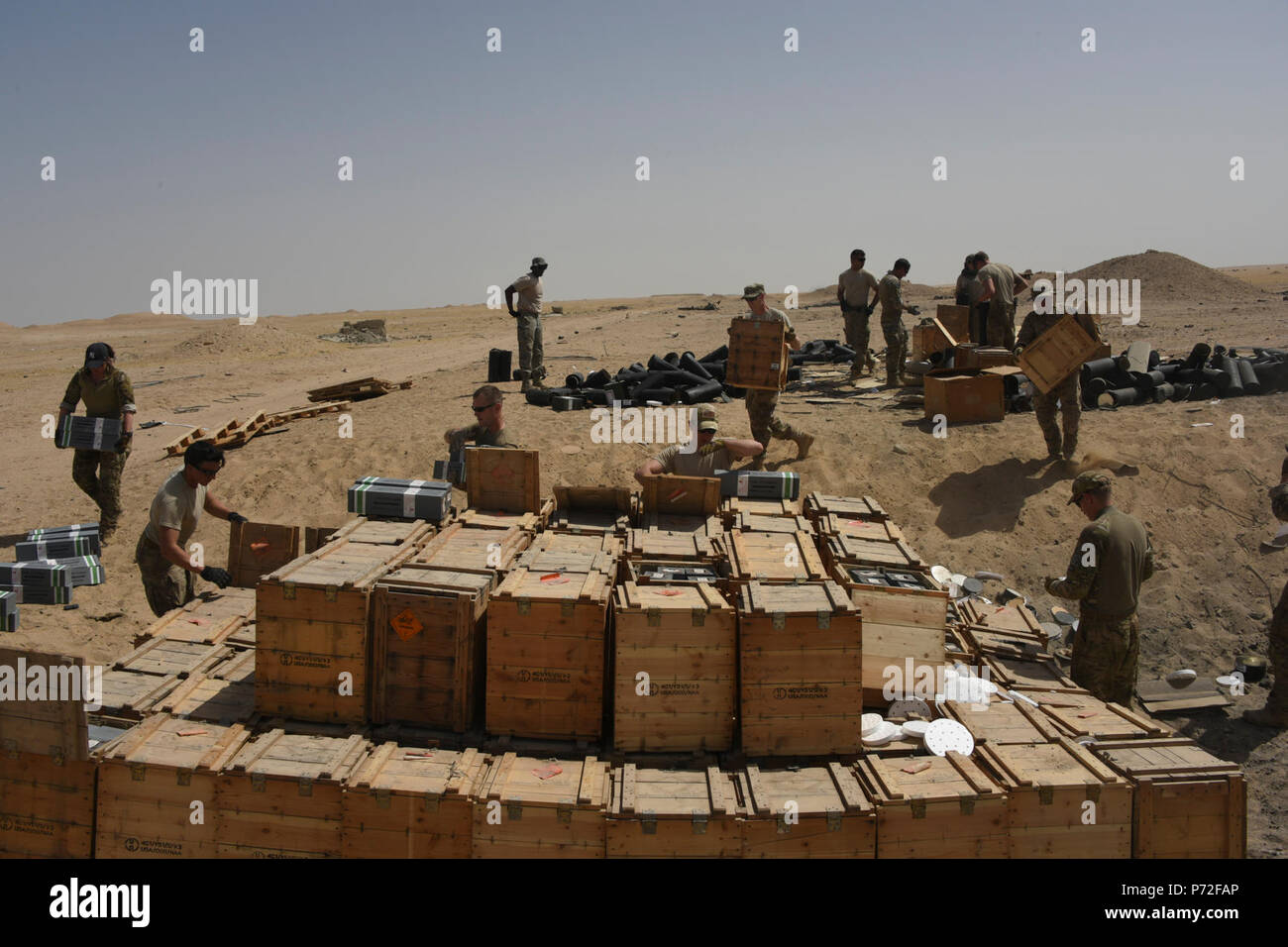 Un groupe de techniciens des explosifs, des munitions et du personnel de la 386e escadre expéditionnaire aérienne ont travaillé ensemble pour disposer d'un camion d'explosés de façon sécuritaire dans un endroit inconnu en Asie du Sud-Ouest, le 11 mai 2017. Le stock de munitions expiré composée principalement de fusées a été transporté d'un endroit isolé où les articles inutilisables ont été empilés dans un trou à l'homme en vue de la destruction. Banque D'Images