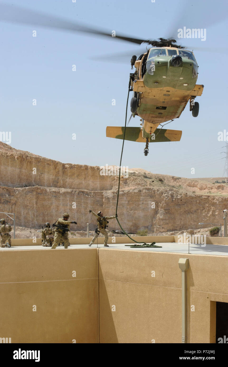 Jordanie (11 mai 2017) Les membres de l'US Air Force Special Operations Forces armées jordaniennes, et Groupe de travail spécial sur la chute rapide de la corde d'un bâtiment, l'interopérabilité au cours d'une formation de recherche et sauvetage de combat au King Abdullah II Centre de formation d'opérations spéciales, dans le cadre de l'exercice lion avide. Lion avide est un exercice annuel le Commandement central américain en Jordanie visant à renforcer les relations militaires entre les Etats-Unis, la Jordanie et d'autres partenaires internationaux. La nouvelle édition se compose d'environ 7 200 militaires provenant de plus de 20 nations qui permettra de répondre aux Banque D'Images