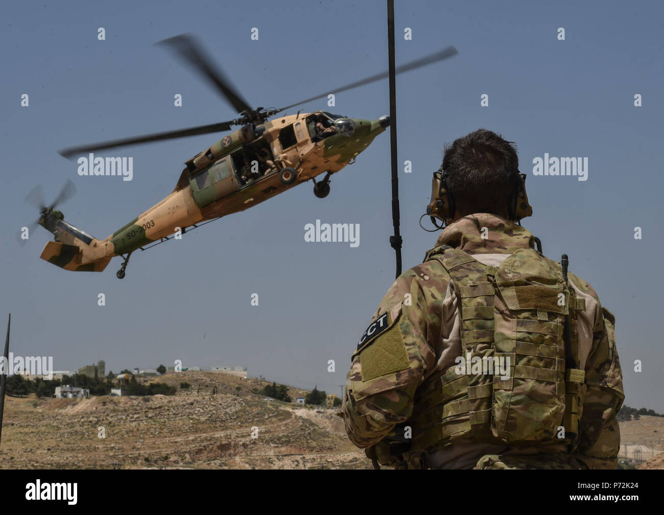 Un U.S. Air Force Special Tactics Airman contrôle l'approche d'un Royal Jordanian Air Force UH-60L hélicoptère Blackhawk pendant l'exercice pour un lion avide de recherche et sauvetage de combat mission de formation le 11 mai 2017, le Roi Abdullah II Centre de formation d'opérations spéciales. Lion avide est un exercice annuel le Commandement central américain en Jordanie visant à renforcer les relations militaires entre les Etats-Unis, la Jordanie et d'autres partenaires internationaux. La nouvelle édition se compose d'environ 7 200 militaires provenant de plus de 20 nations qui permettra de répondre aux scénarios impliquant la sécurité aux frontières, Banque D'Images