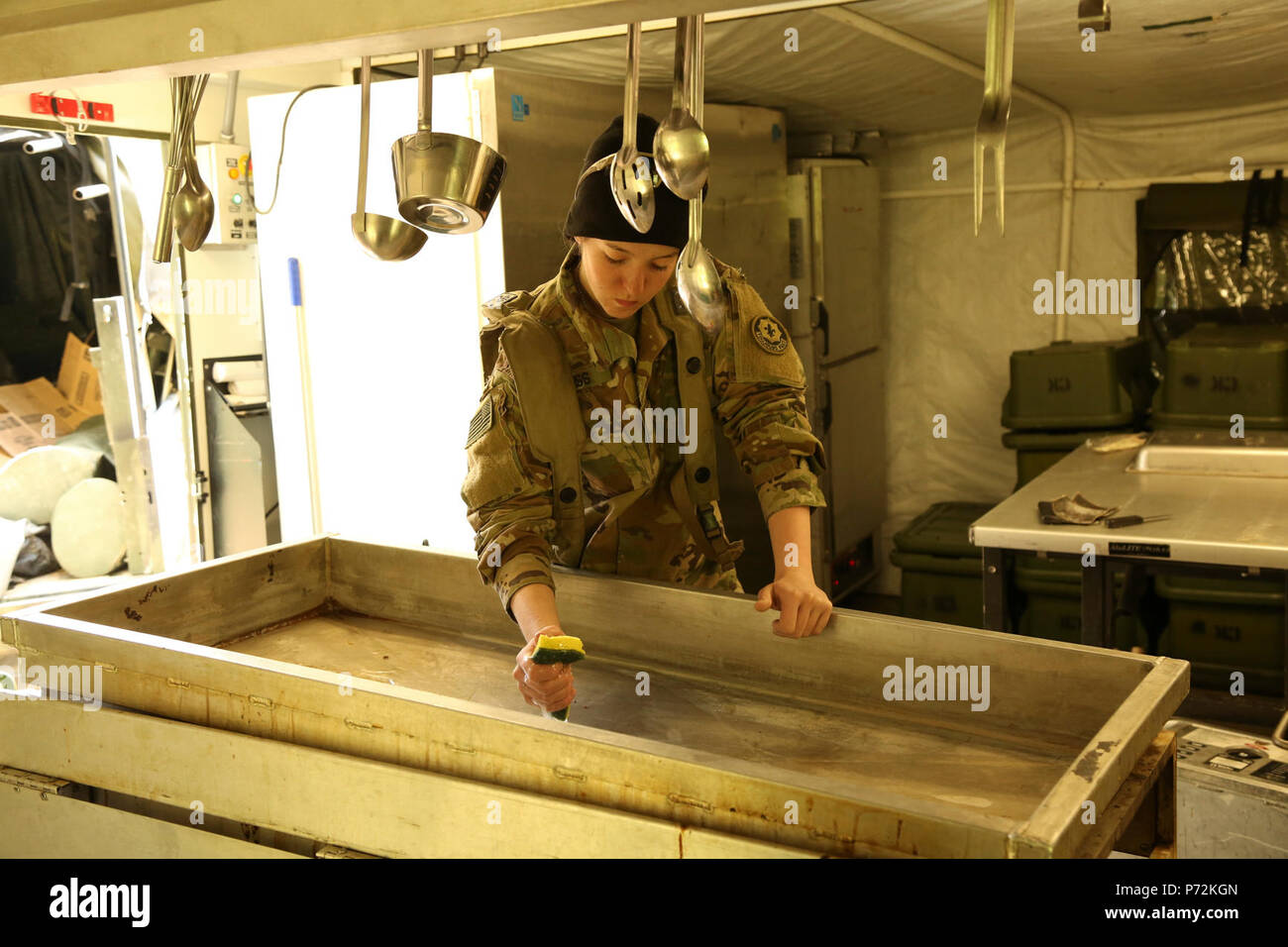 L'ARMÉE AMÉRICAINE Pvt. Danielle Weiss de l'Escadron de soutien régimentaire, Régiment de cavalerie 2d permet de nettoyer les ustensiles de cuisine tout en effectuant les tâches culinaires durant 17 à la jonction de Sabre Hohenfels Domaine de formation, l'Allemagne, le 11 mai 2017. Sortie 17 Sabre est l'armée américaine Europe's Cavalry Regiment 2d centre de formation de combat de l'exercice de certification, qui aura lieu au Centre de préparation interarmées multinationale à Hohenfels, Allemagne, Avril 25-Mai 19, 2017. L'exercice a pour but d'évaluer l'état de préparation du régiment pour mener des opérations terrestres unifiée, avec un accent particulier sur la transition de répétitions Banque D'Images