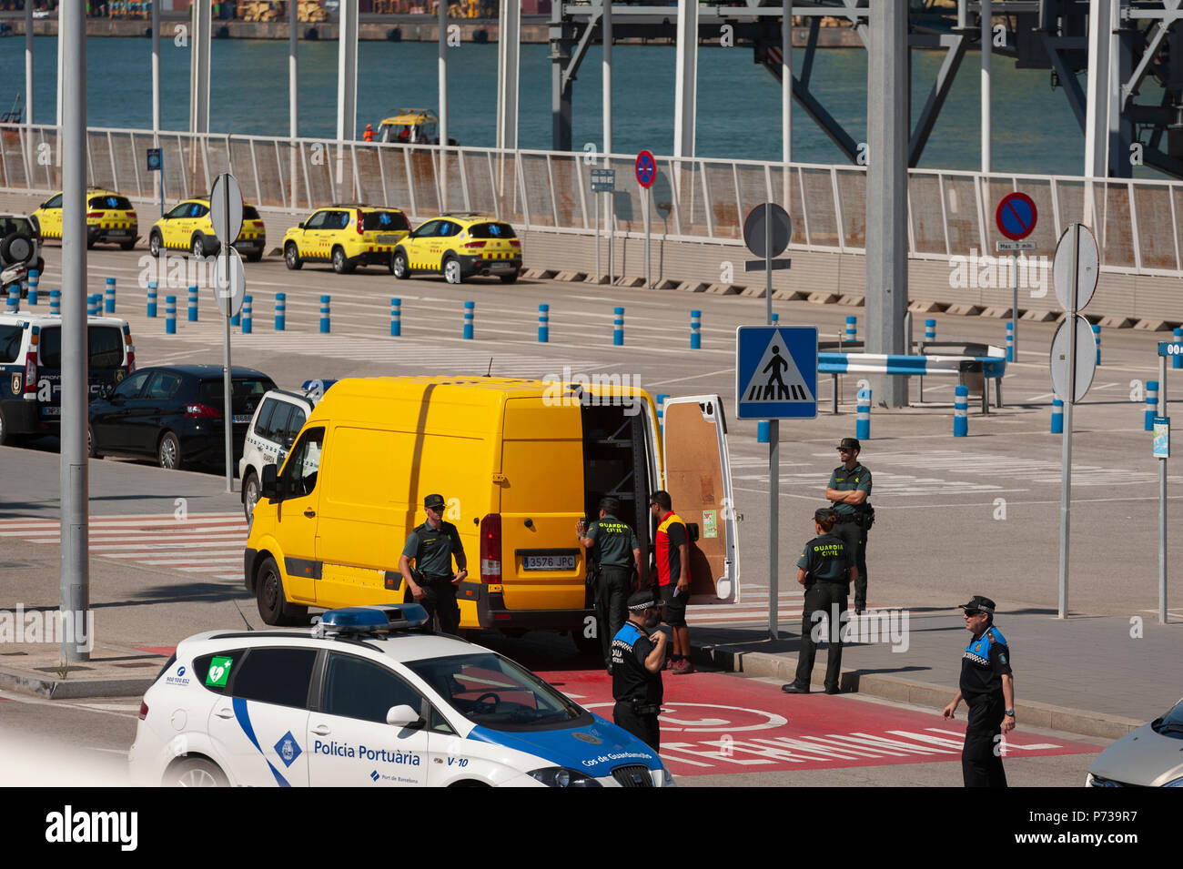 Barcelone. Le 04 juillet, 2018. Les membres de la police de la garde civile, inspecter tous les véhicules qui tentent d'accéder au quai où le bateau de l'ONG Proactiva bras ouverts. Le bateau a navigué jusqu'à l'aide humanitaire Espagne avec 60 immigrants de 14 nationalités ont sauvé le samedi dans les eaux près de la Libye, après qu'il a été rejeté par l'Italie et Malte. Banque D'Images