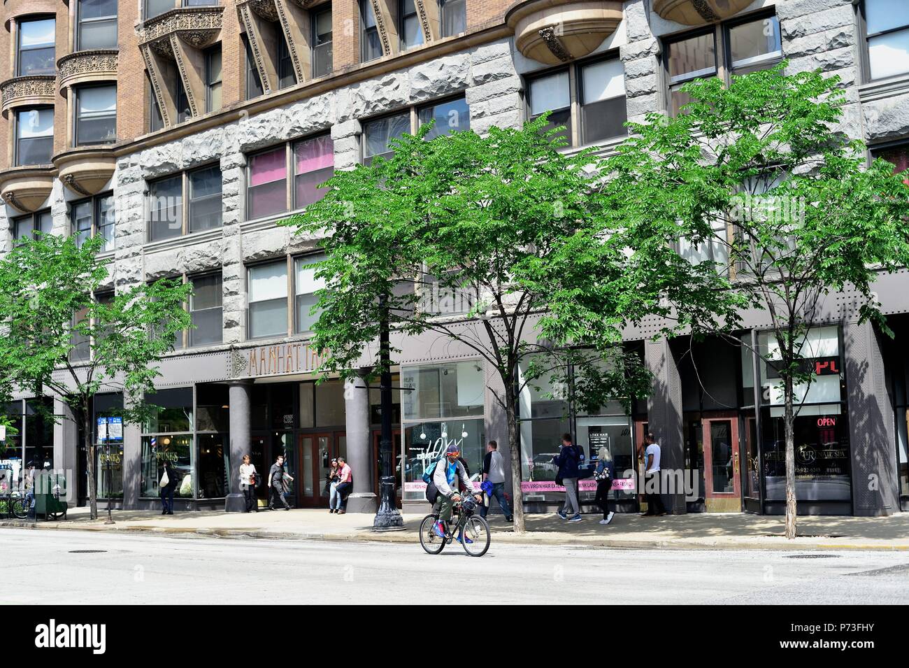 Chicago, Illinois, USA. Un seul cycliste à pédaler contre le trafic sur Dearborn Street. Banque D'Images