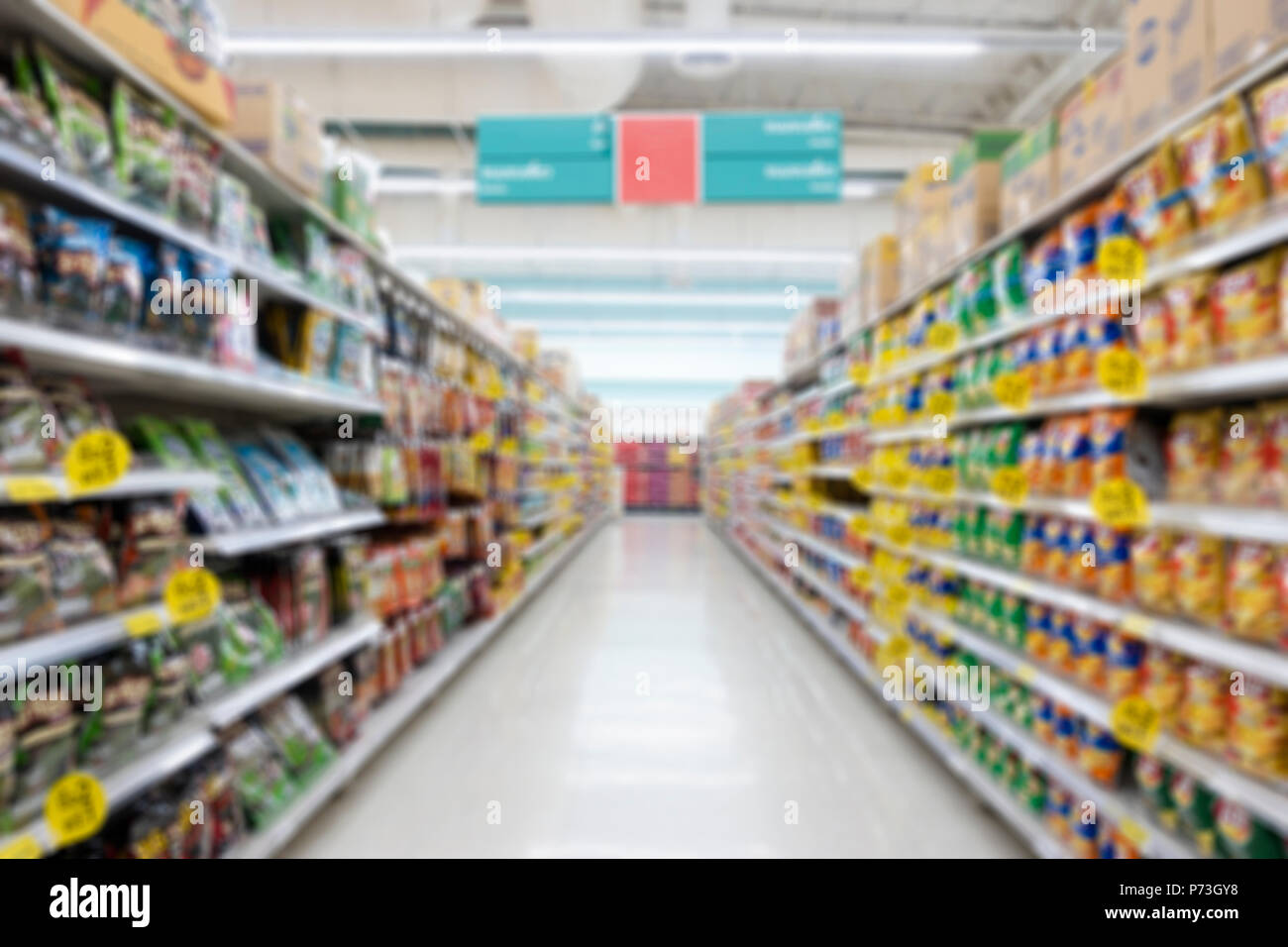 Résumé de l'allée de supermarché floue avec des étagères et méconnaissable clients comme arrière-plan Banque D'Images