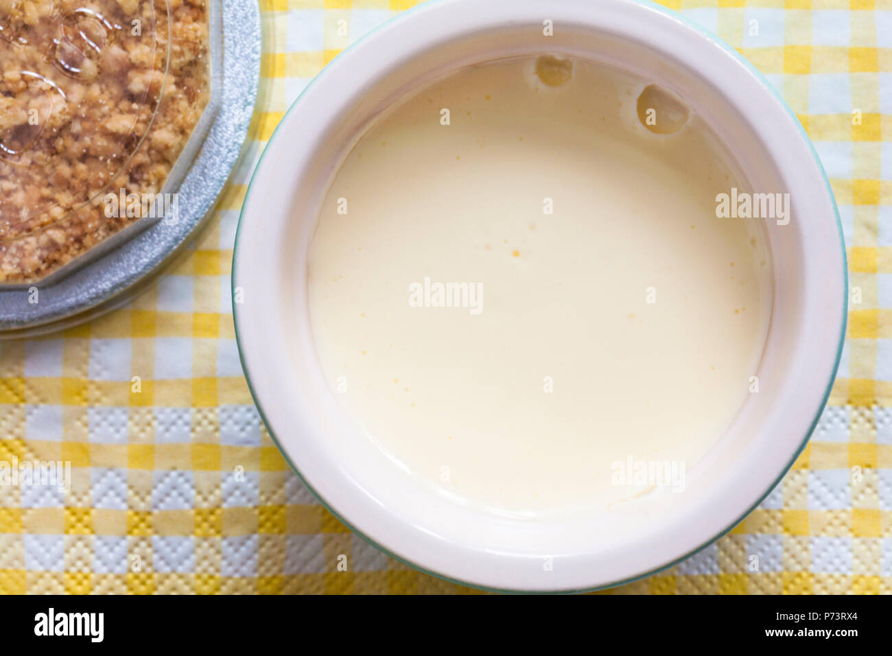 Pots & Co pot de Cheesecake au citron à la main avec un biscuit crumb top hat jeu pouding sur jaune et blanc vérifié serviette serviette Banque D'Images