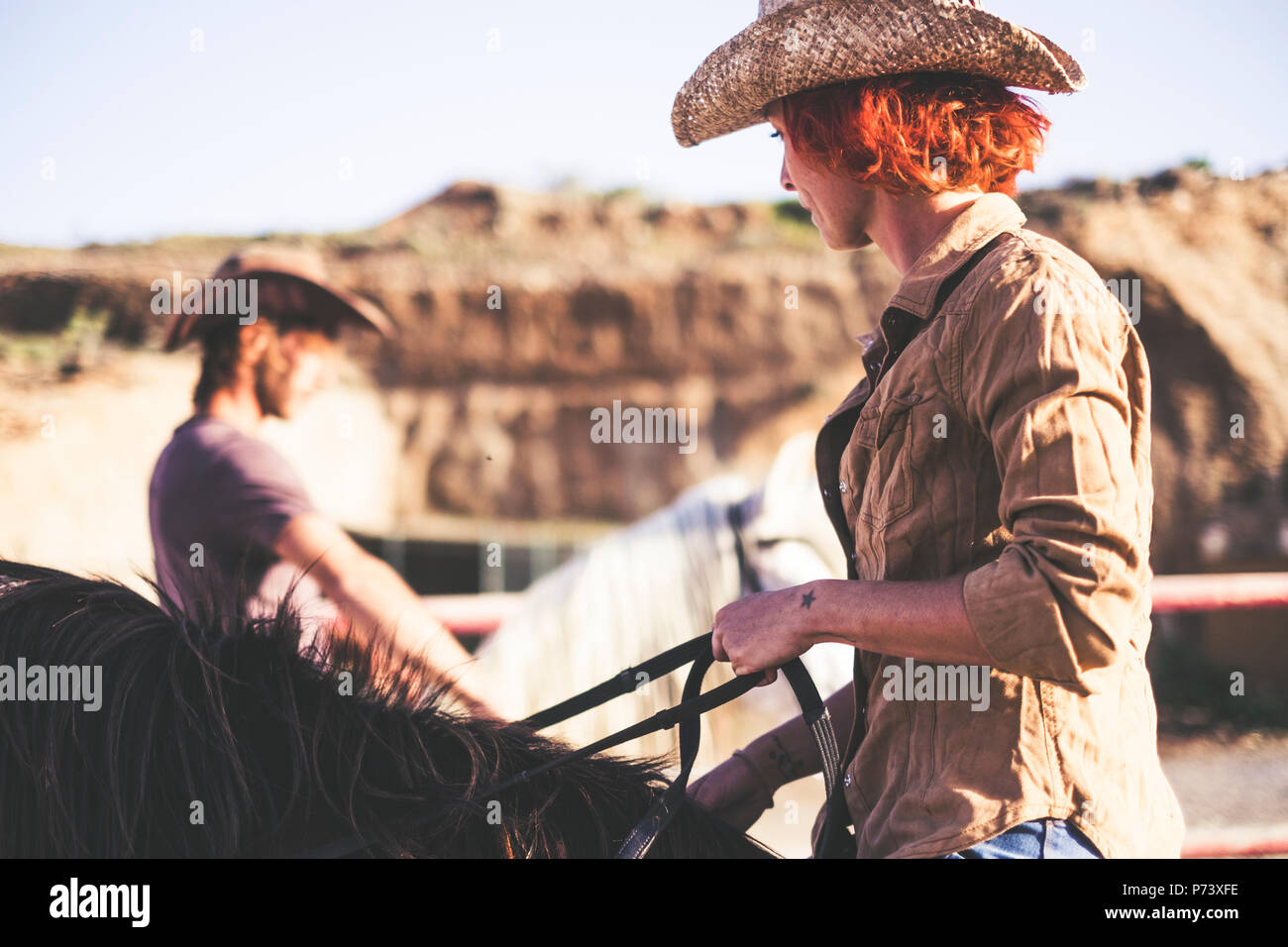 Couple de cowboy moderne. rouler ensemble un homme et une femme avec deux chevaux. filtre chaud pour image style de vie et de travail ou d'activité en plein air Banque D'Images