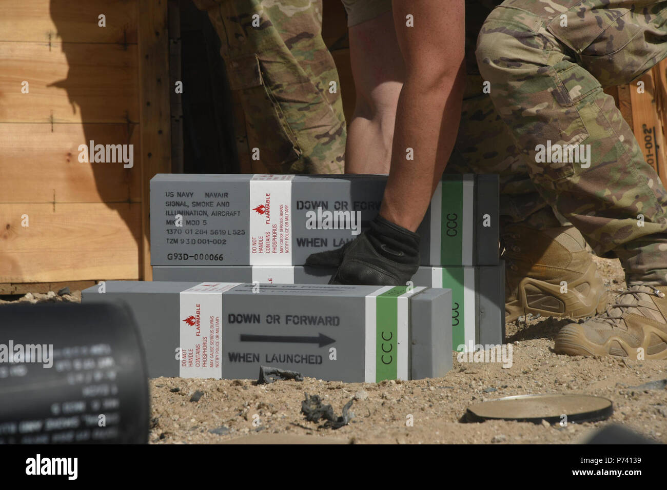 Un technicien des explosifs et munitions avec le 386e Escadron de génie civil de la Force expéditionnaire du Canada, se prépare à soulever une pile des torches au cours d'une demande d'élimination de munitions dirigé dans un endroit inconnu en Asie du Sud-Ouest, le 11 mai 2017. Un groupe de techniciens de NEM, des munitions et du personnel de la 386e escadre expéditionnaire aérienne ont travaillé ensemble pour disposer d'un camion de expiré explosés de manière sûre à un endroit isolé. Banque D'Images