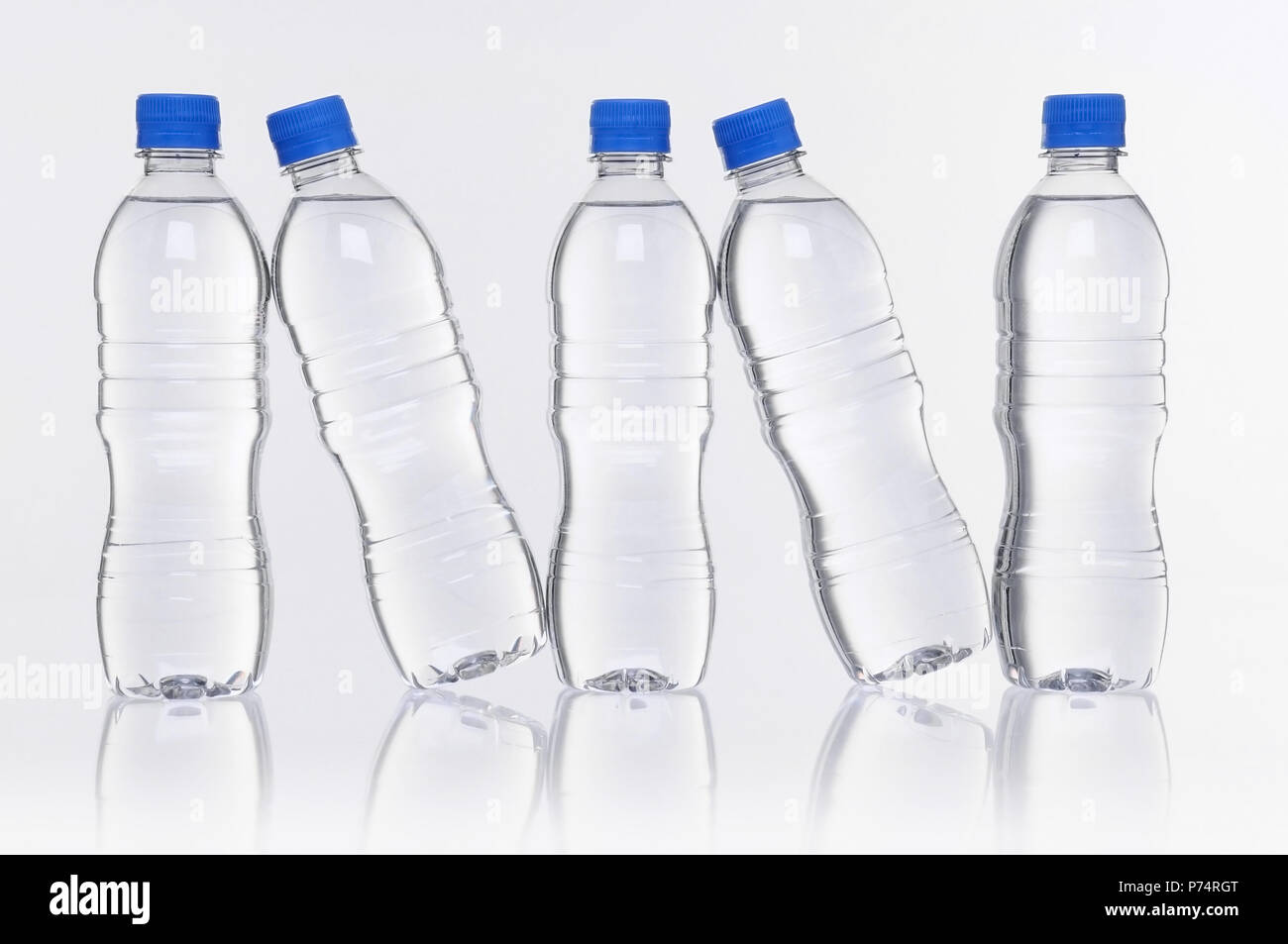 Rangée de cinq bouteilles d'eau en plastique avec réflexion Banque D'Images