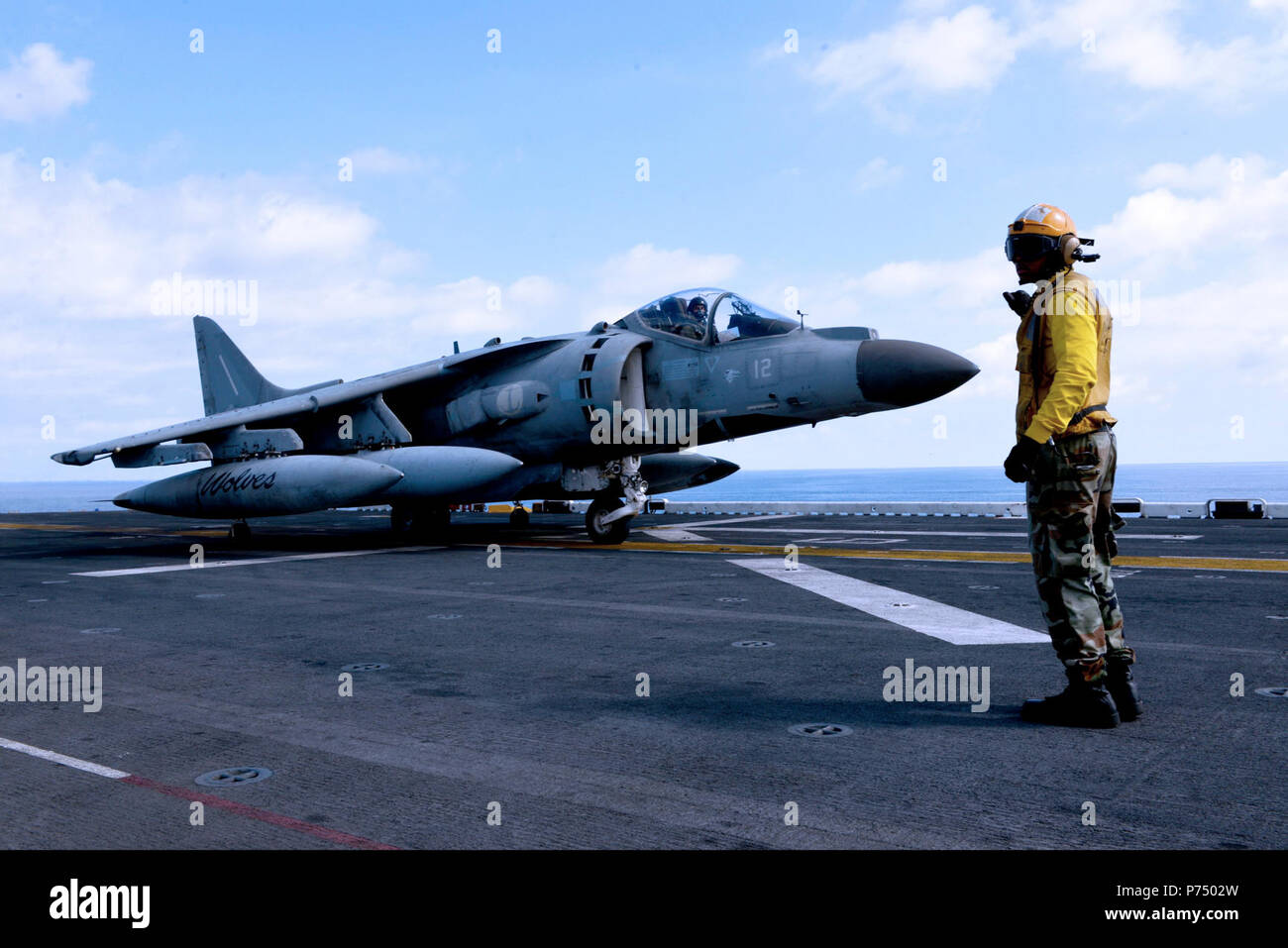 Mer (oct. 9, 2014) - Aviation maître de Manœuvre (manutention) 3e classe Andrew Sterling, de Chicago, dirige un AV-8B Harrier italien à bord du navire d'assaut amphibie USS Bataan (DG 5). Le groupe amphibie Bataan est sur un déploiement prévu des opérations de sécurité maritime, offrant une capacité d'intervention de crise et les efforts de coopération en matière de sécurité dans le théâtre de la sixième flotte américaine zone d'opérations. Banque D'Images