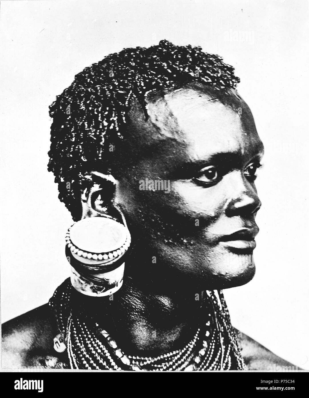 Portrait buste d'homme africain avec pot de confiture accrochée à son oreille, au Kenya 1880-1923 Banque D'Images