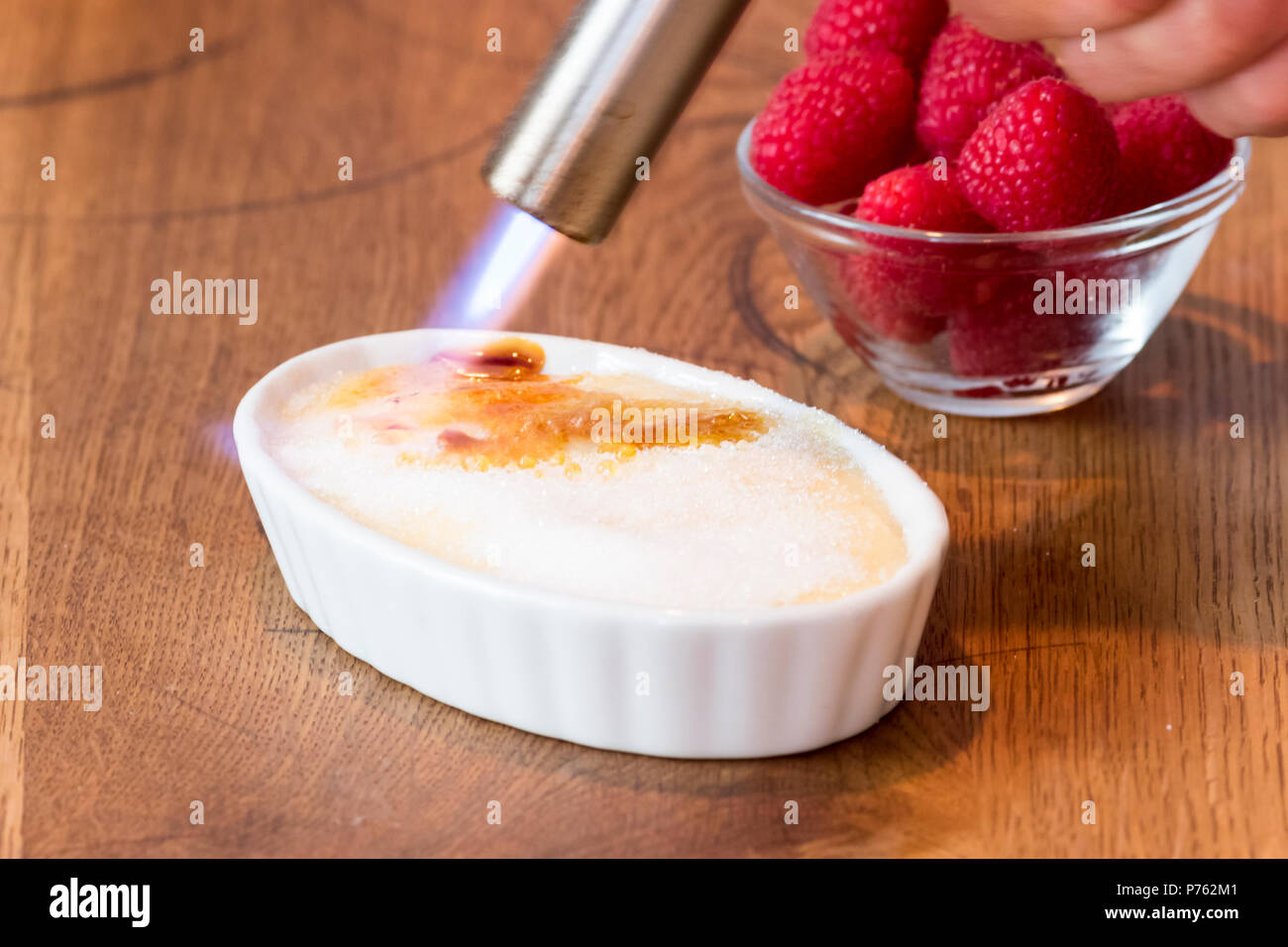 Crème catalane sur table en bois en blanc bol à fruits rouge Banque D'Images