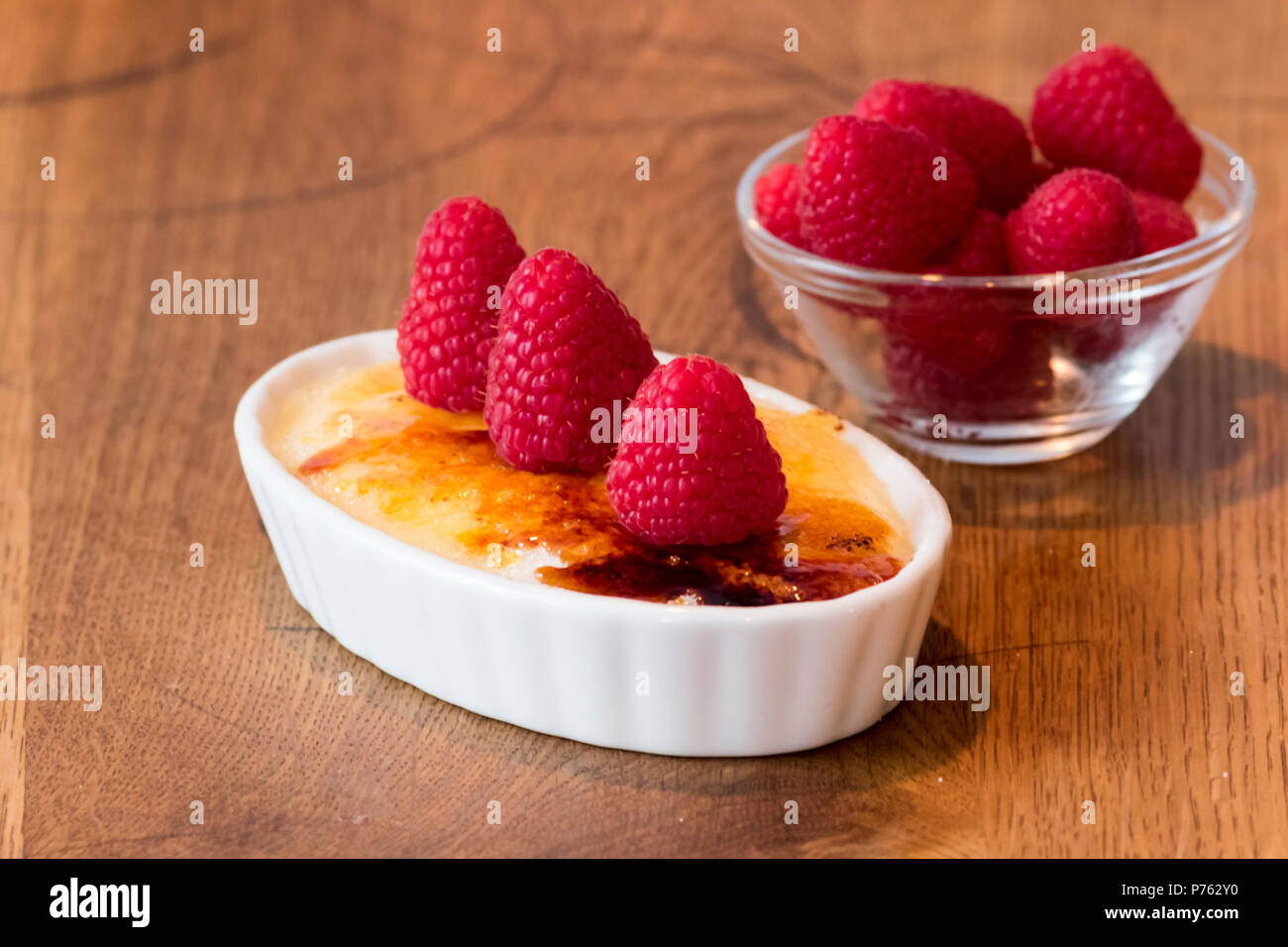 Crème catalane sur table en bois en blanc bol à fruits rouge Banque D'Images
