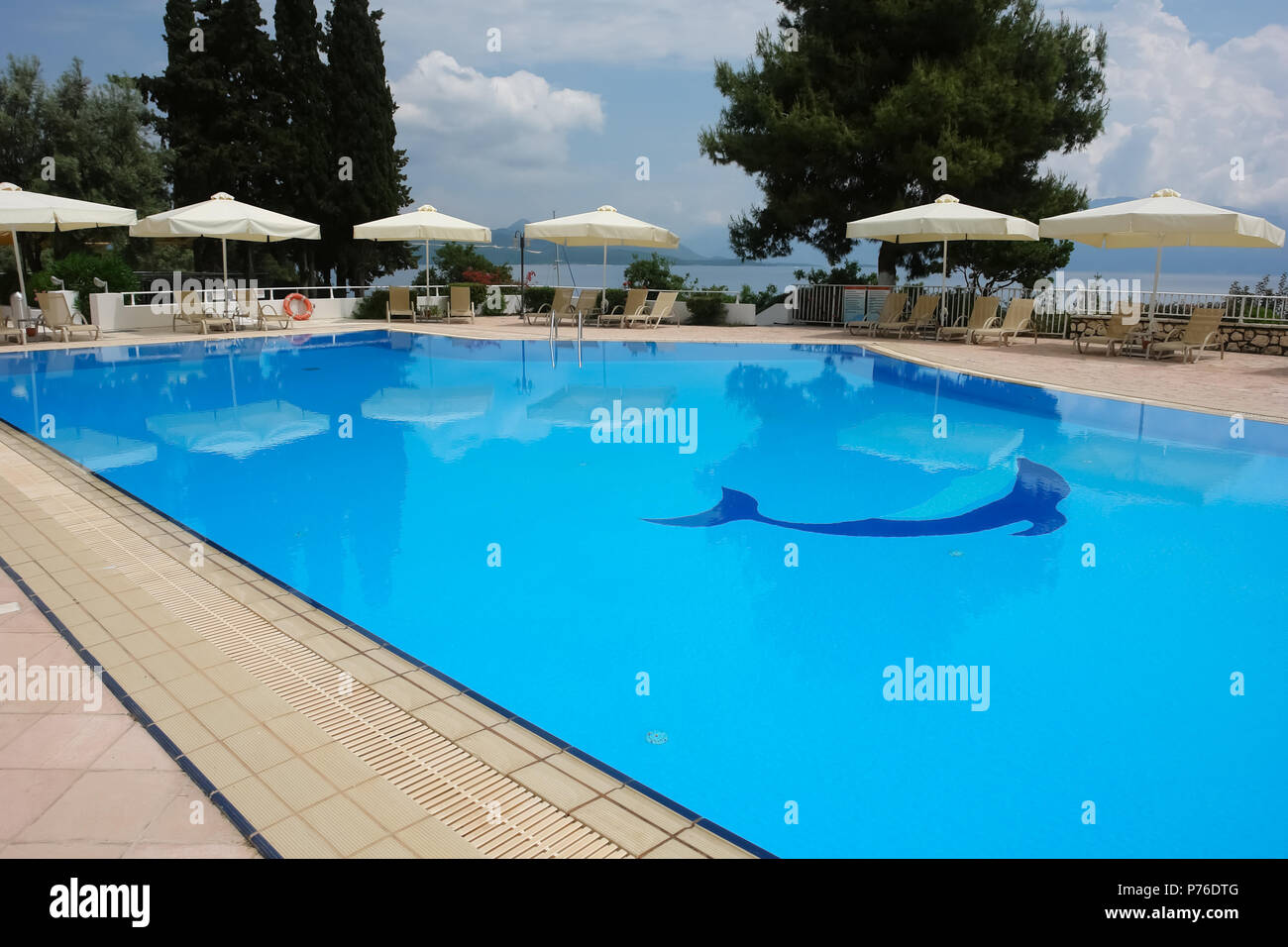 Lefkada, Grèce - 11 mai 2013 : vue sur la piscine et parasols blancs en hôtel moderne sur la côte de la mer Ionienne, en Grèce. Banque D'Images