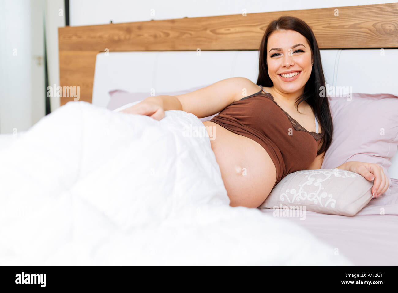 Portrait de femme enceinte dans le lit Banque D'Images