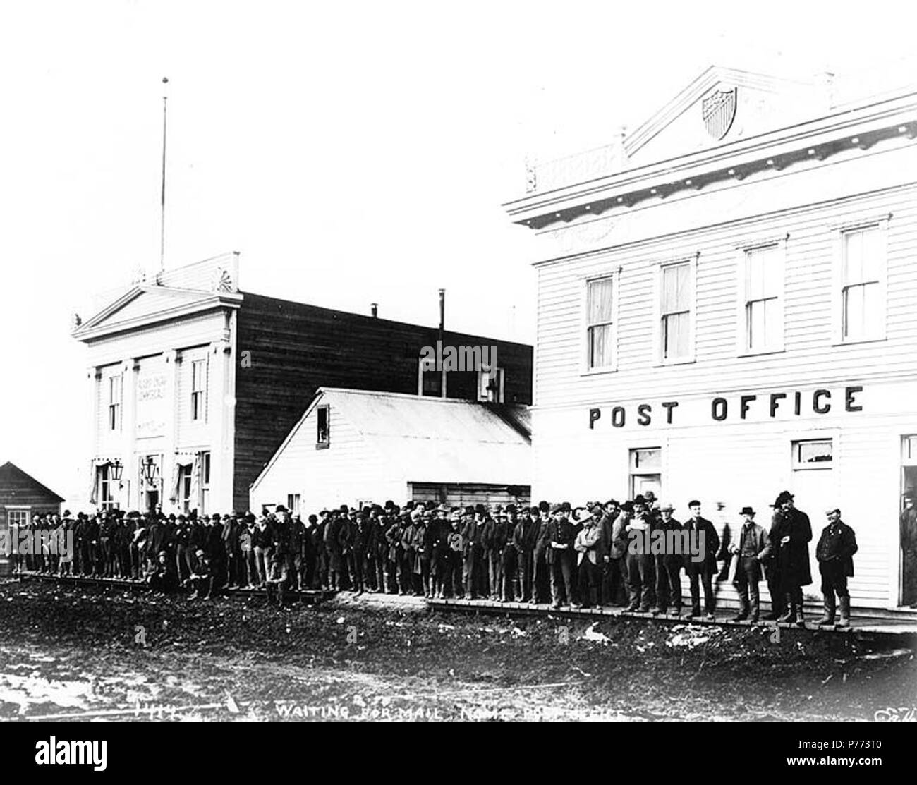 . Anglais : Ligne d'hommes en attente de courrier à l'Office de poste de Nome, Alaska, ca. 1901. Anglais : Légende sur l'image : 'En attente de poste, bureau de poste Nome' image d'origine dans l'album 38 Hegg, page 45. Sujets (LCTGM) : bureaux de poste--Alaska--Nome ;--Files d'Alaska--Nome . vers 1901 7 Ligne d'hommes en attente de courrier à l'Office de poste de Nome, Alaska, ca 1901 (HEGG 200) Banque D'Images