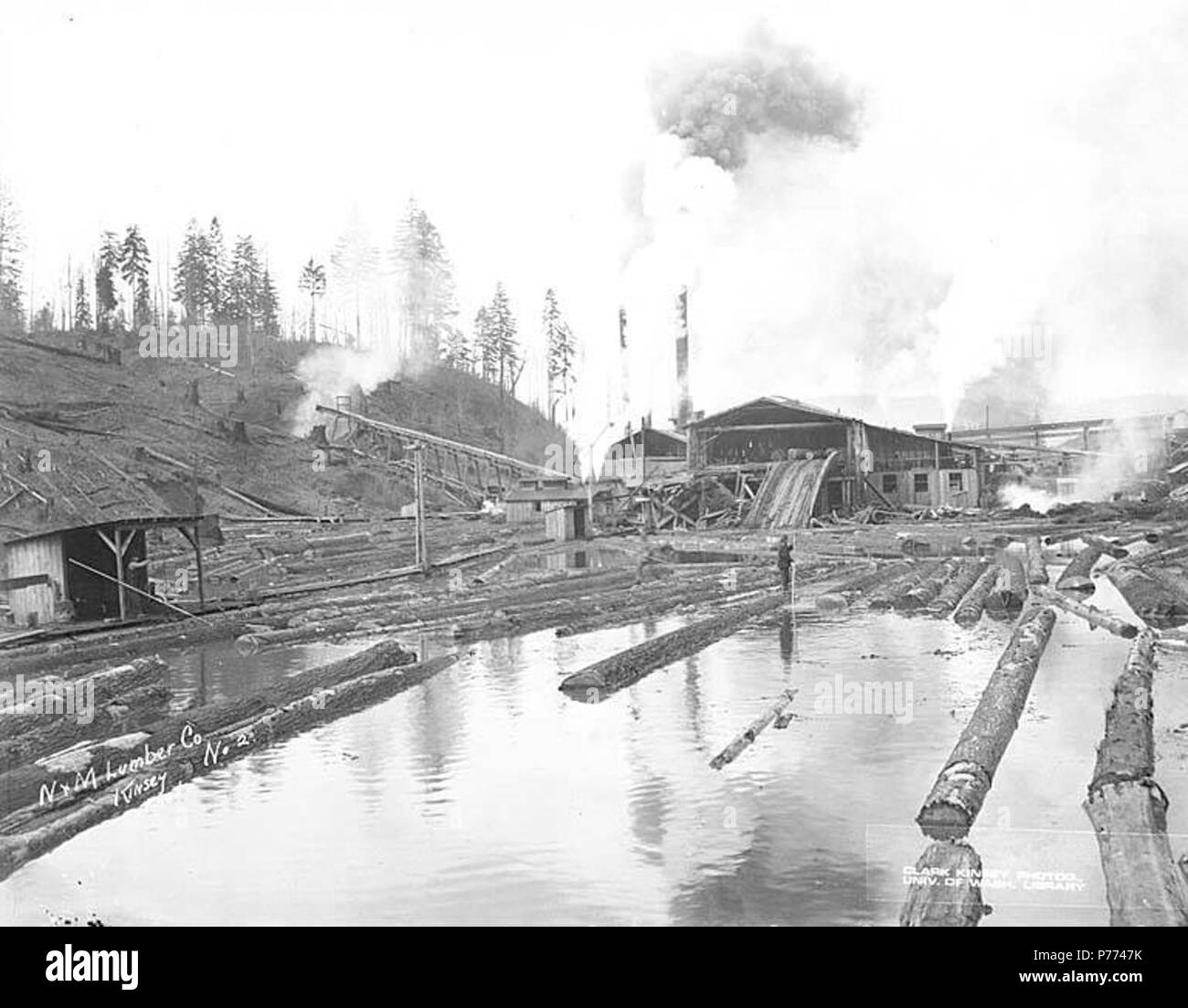 . Anglais : scierie et mill pond, N et M Lumber Company, Rochester, ca. 1920 . Anglais : Légende sur l'image : N&M Lumber Co. Kinsey Photo. No 2 PH Coll 516,2183 N&M Lumber Company a été en affaires dans la région de Rochester au début des années 1920, avec une scierie et exploitation forestière. Rochester est une communauté d'une vingtaine de kilomètres au sud d'Olympie, dans le sud-ouest des Prairies boulangers sur Thurston Comté. Lorsqu'un bureau de poste a été créé en 1890, le nom choisi a été la clé, peut-être parler de ville de passage sur l'ouest. À une époque, la ville comptait un hôtel, grand magasin et trois scieries. En 1904, le nom actuel a été subst Banque D'Images