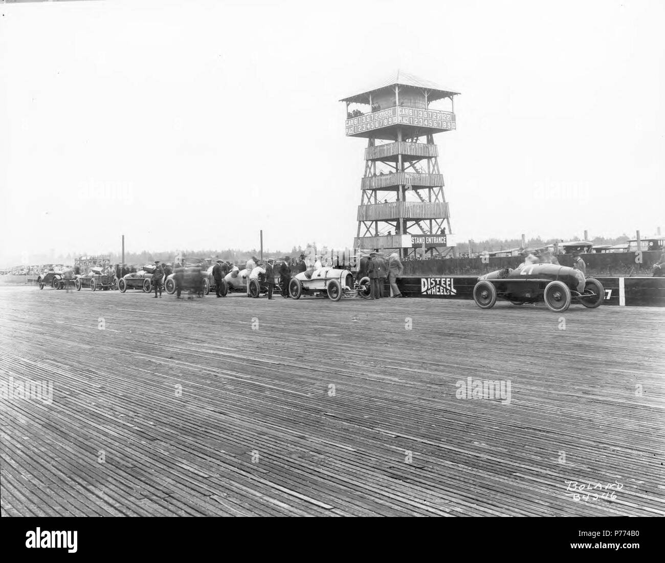 . Marvin D. Collection Boland BOLAND-B4346. Le 4 juillet 1921, certaines des voitures participant à la 10e édition de la Speedway Classic sont alignés sur la voie d'administration. Dans le plomb est # 27 Tom Alley Frontenac suivie par # 1 Eddie Hearne's big white Revere spécial. Le Speedster Marmon pace car, qui serait conduit par Ray Harroun, ferme la marche. Dans l'arrière-plan est la tour d'observation du juge. Vingt mille spectateurs pour applaudir les 9 pilotes dans les 250 km course. Fini les pilotes dans l'ordre suivant : Milton, Sarles, Thomas, Hearne, Allée et Miller. Pullen et Elliott étaient flagge Banque D'Images