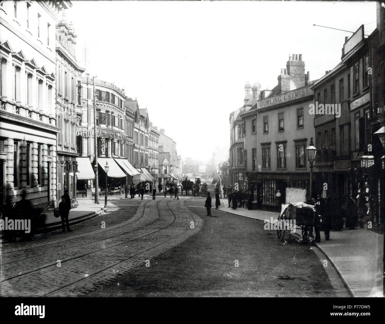 Anglais : King Street, Reading, à l'Est de Kings Road, ch. 1880. Sur la gauche, nos 4 et 5 (John et Charles Simonds et compagnie, banquiers) ; nos 1 et 2 (Edward Margrett, quincaillerie) ; No 1 Kings Road (Edward Jackson, pourvoirie). Sur la droite, n° 2 Kings Road (William Shepherd, épicerie et du vin et de l'esprit commerçant) ; No 24, rue King (Robert Dowling, chimiste) ; No 23 (James D. George, pâtisserie) ; Nos 21 et 22 (J. Chesterton et Shaw (gentlemen's Outfitters) ; une partie de nos 17 et 18 (Edwin P. Argent, messieurs's outfitter). 1880-1889 : photo d'un négatif sur verre par H. W. Taun Banque D'Images