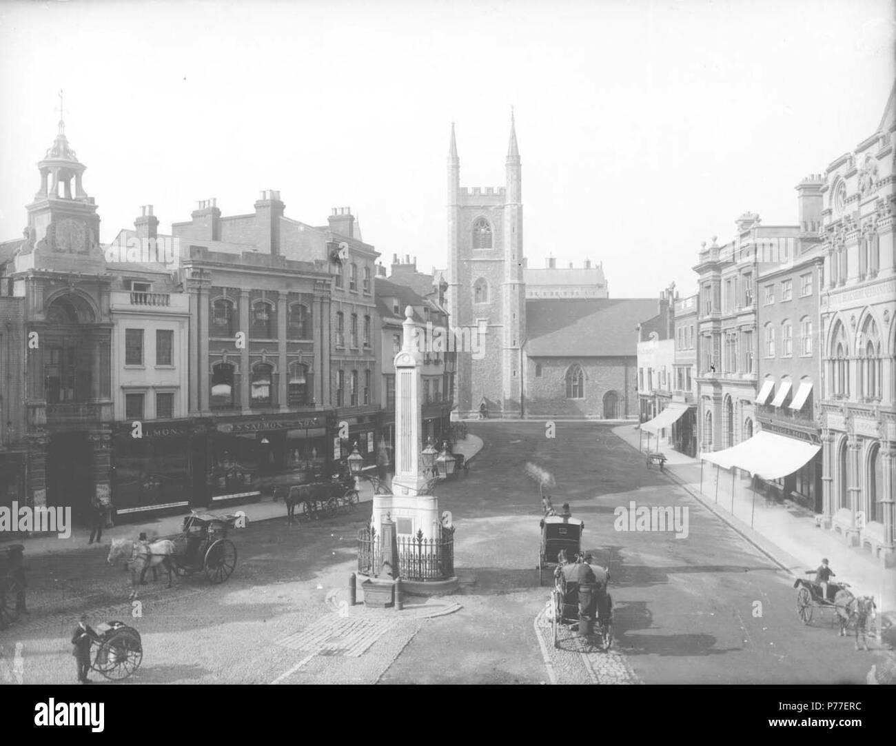 Anglais : Market Place, la lecture, regarder vers le nord de l'église Saint-Laurent, c. 1875. Sur le côté ouest, l'entrée de la halle au blé avec horloge ci-dessus ; Nos 34 et 33 (saumons et Fils, thé et café marchands) ; n° 32 ; Nos 31 et 30 ; no 29 (Arthur S. Cooper, du vin et de l'esprit marchand). Sur le côté est, nos 19 et 18 (Hôtel de l'éléphant) ; No 17 (Frank Cooksey, agent immobilier) ; Nos 16, 15, 14 et 13 (comté de Londres et Banque mondiale) ; No 12 (Morris et Davis, tailleurs) ; Nos 11 et 9 (Sutton et fils, les semenciers) ; et No 7 ('Lecture Le Mercure" bureaux). Deux noirs sont stationnés par l'obélisque de Siméon, qui dispose d'un pum Banque D'Images