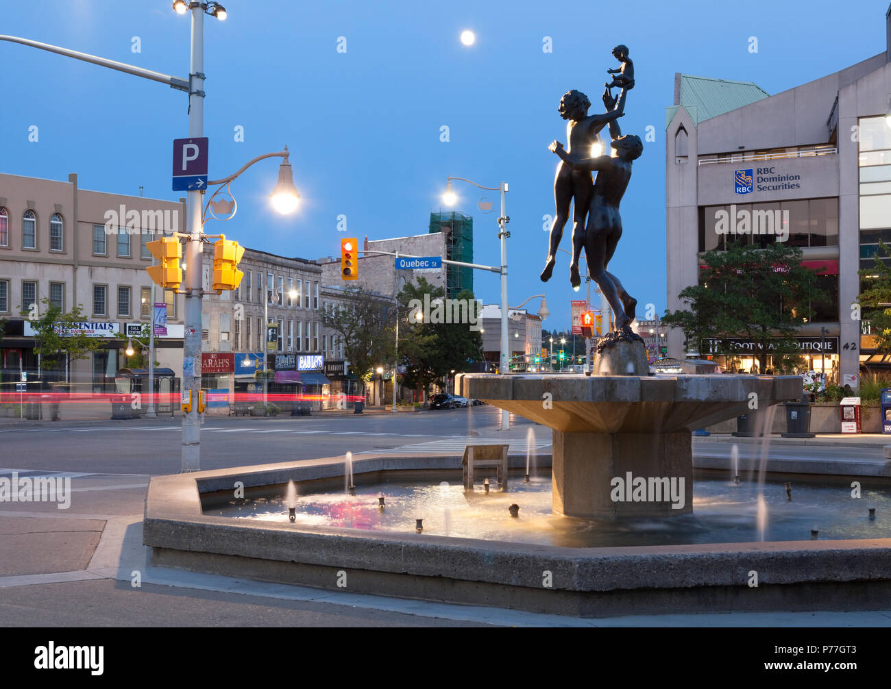 'La famille' sculpture et fontaine dans St George's Square au crépuscule au centre-ville de Guelph, Ontario, Canada. Banque D'Images