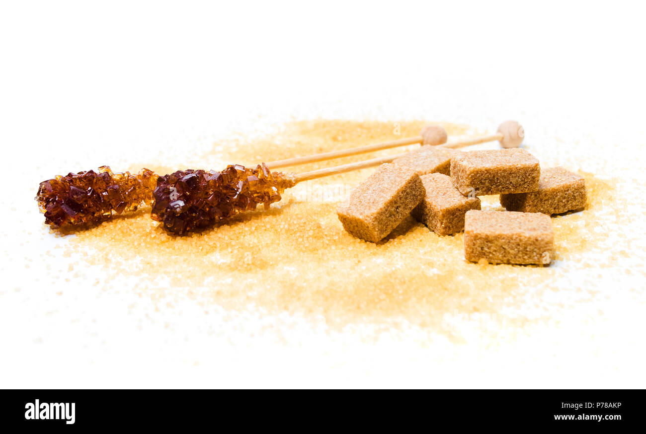 Bâtonnets de sucre brun, cristaux et cubes on white Banque D'Images