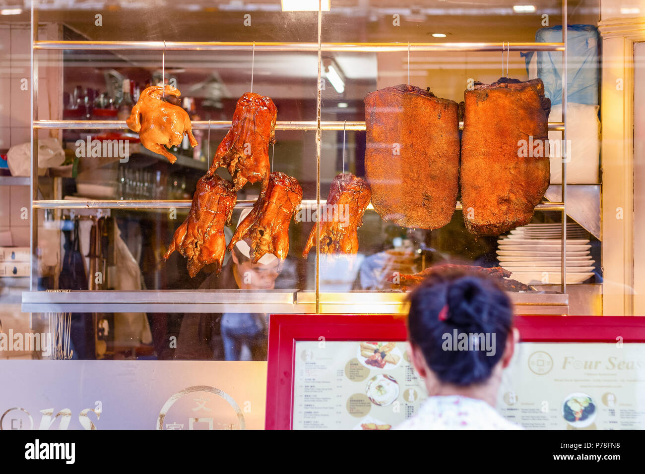 Londres, Royaume-Uni - 22 juin 2018 - Le tourisme est en train de lire le menu à l'extérieur restaurant Four Seasons, célèbre pour le croustillant de canard, Chinatown à Londres Banque D'Images