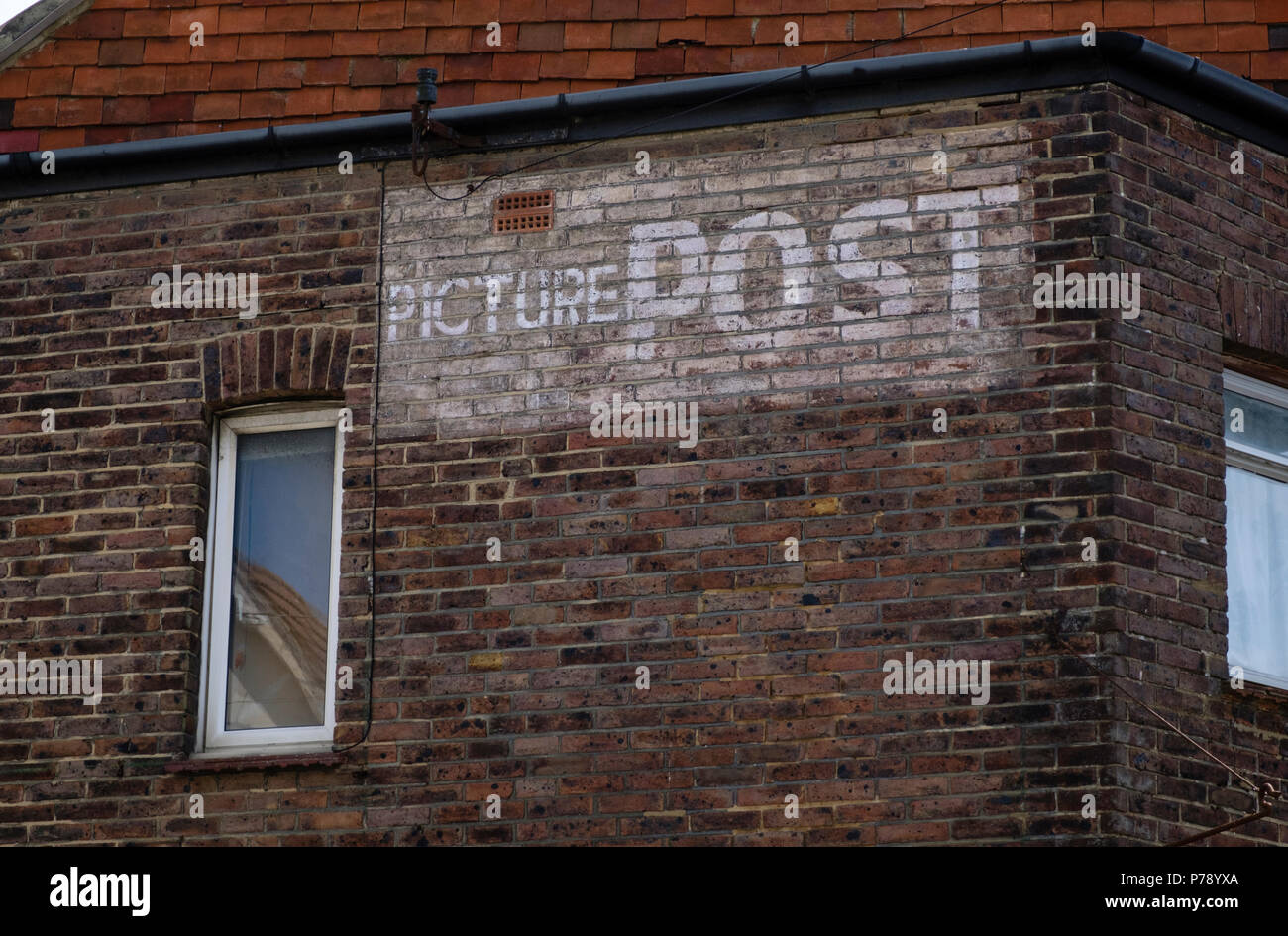 Photo Poster annonce sur le côté d'une maison à Bexhill on Sea Banque D'Images