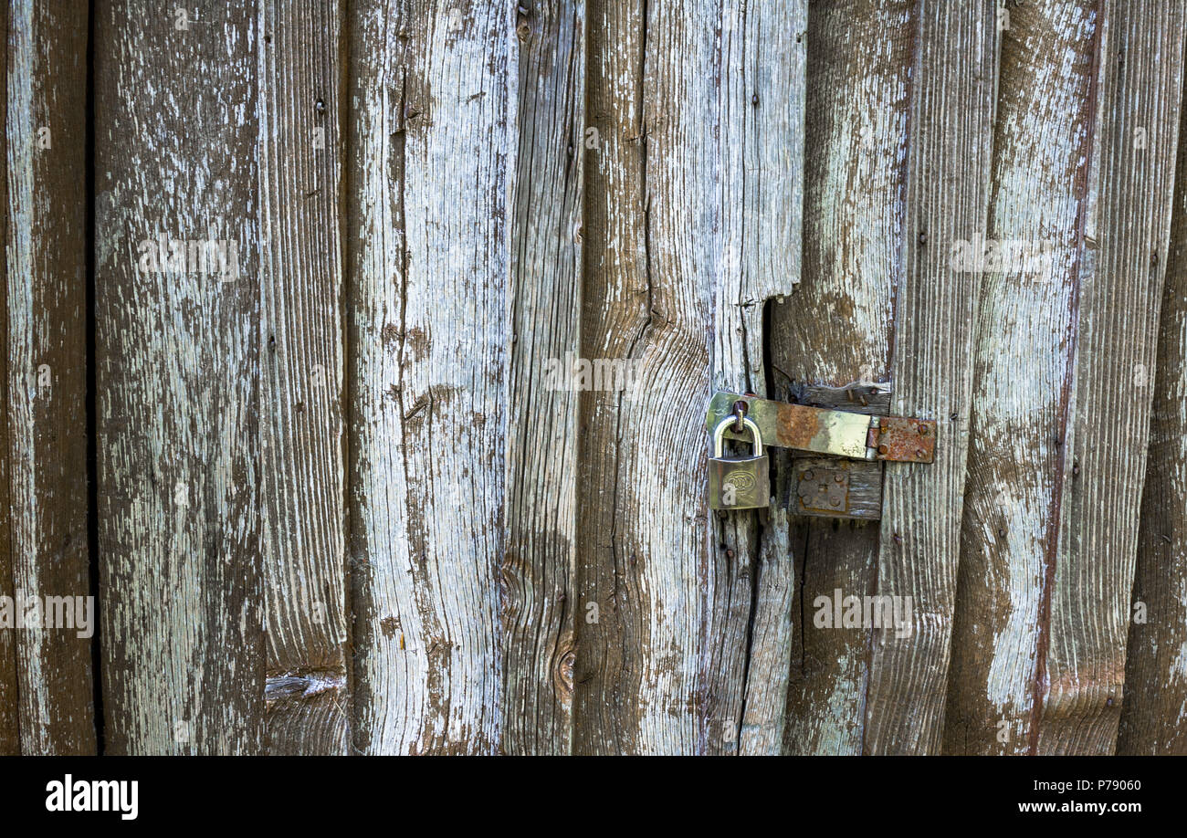 Cadenas fermé sur une ancienne porte de protection boisée. Banque D'Images