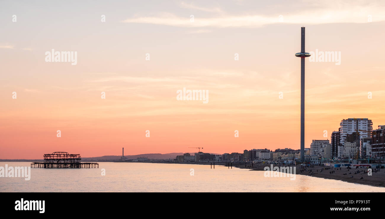 British Airways j360 et West Pier, Brighton, East Sussex, y compris le front de mer au coucher du soleil avec ciel jaune et orange intense Banque D'Images