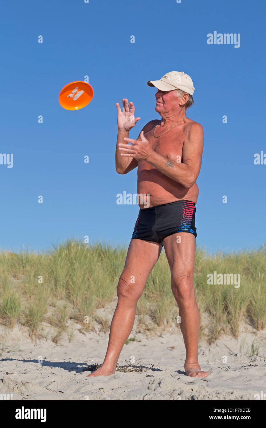 L'homme jouant avec un frisbee Disque au niveau de la plage, plage, Wustrow, Fischland, Schleswig-Holstein, Allemagne Banque D'Images