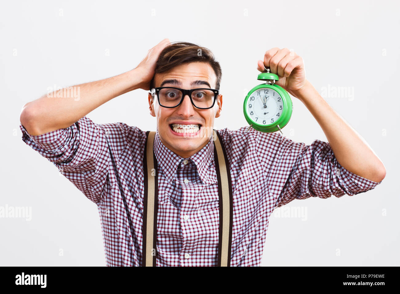 L'homme panique dans nerdy holding clock. Banque D'Images
