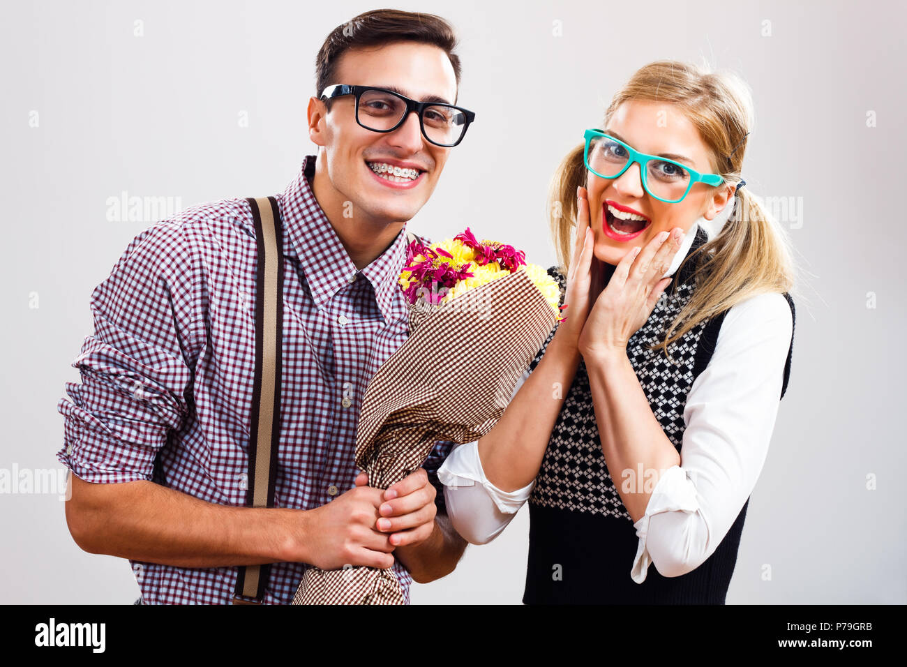 L'homme est nerdy donnant des fleurs à son nerdy dame. Banque D'Images