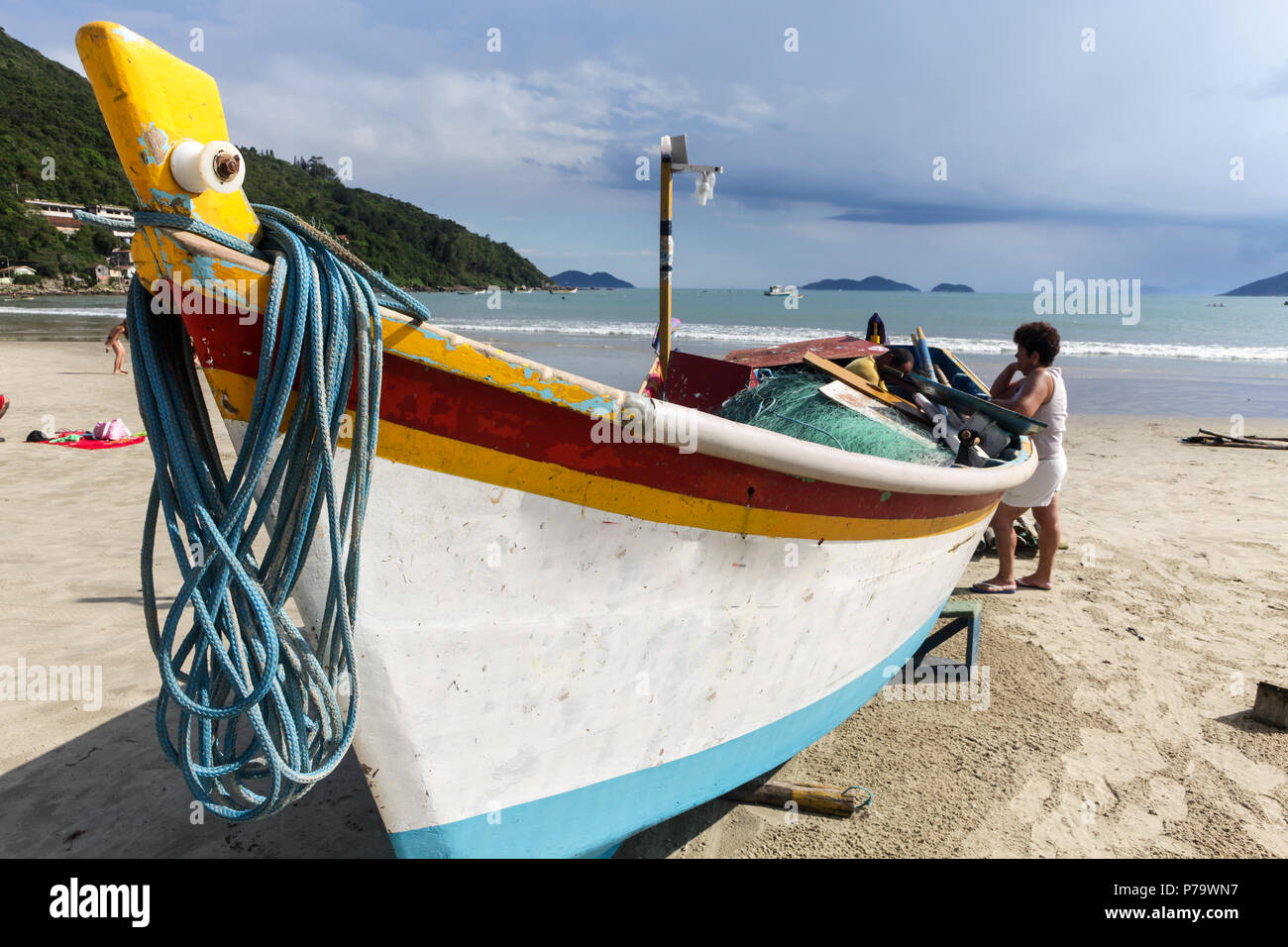 Florianopolis, Santa Catarina, Brésil. La fixation d'un bateau de pêcheur avec son épouse sur la plage. Banque D'Images