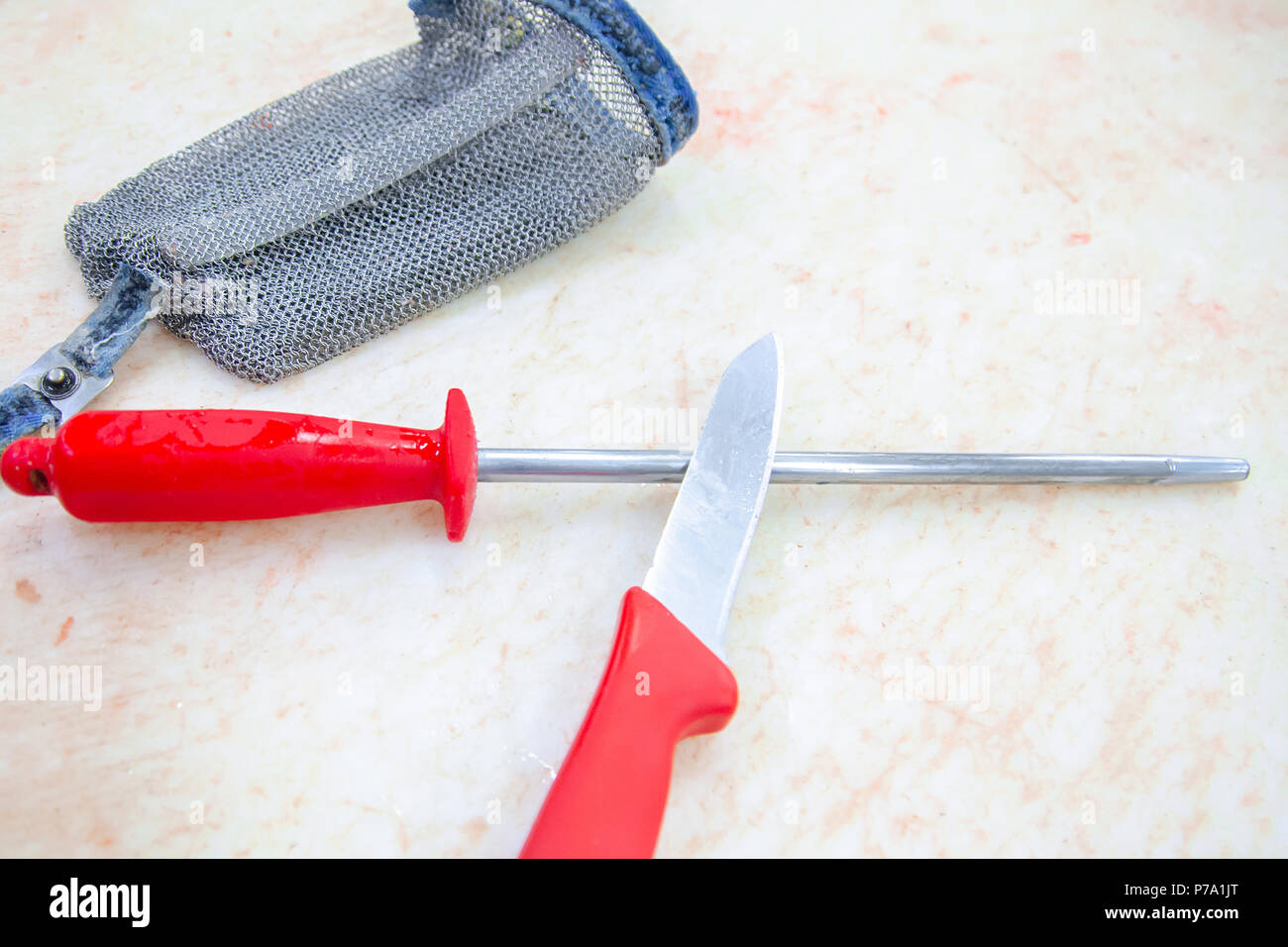 Le couteau d'un boucher, d'argent et sur un gant moussat blanc planche à découper. Banque D'Images