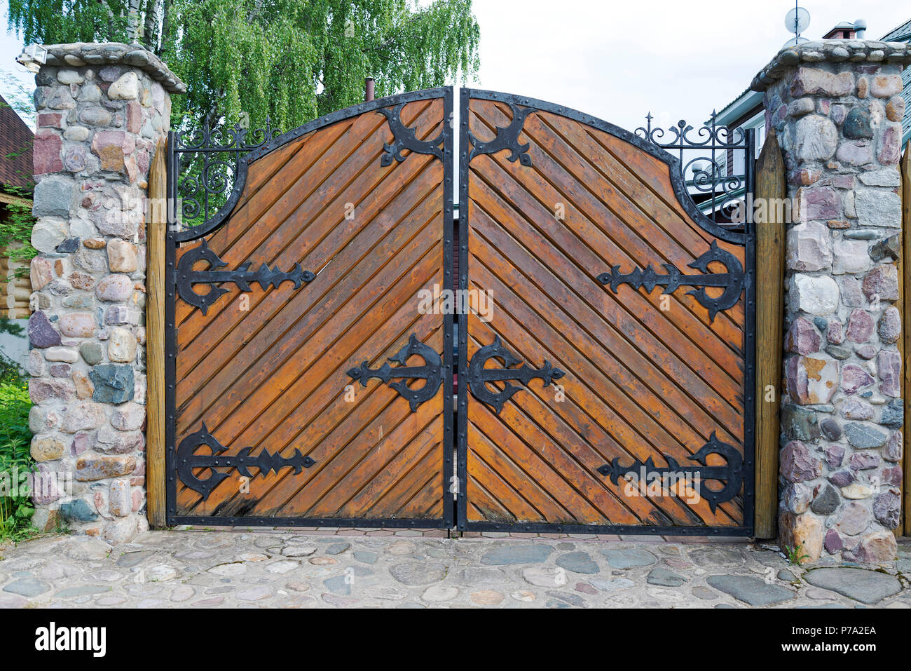 Porte en bois avec des éléments en fer forgé. L'entrée pour les voitures  Photo Stock - Alamy