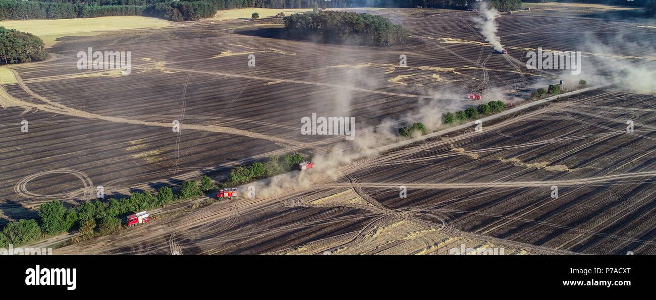 Allemagne, Limsdorf. 4 juillet, 2018. Les voitures de pompiers sur le terrain. L'incendie qui a attrapé sur quelque 100 hectares de forêts et de terres sur le terrain a été mis sur le jeudi soir. Plus de 13 heures ont été nécessaires pour éteindre le feu dans le district de Limsdorf, comme le service des incendies déclarés. La police n'est pas encore en mesure de fournir une source pour le feu. Le Brandebourg est en ce moment à son plus haut risque pour les incendies de forêt. Crédit : Patrick Pleul/dpa-Zentralbild/dpa/Alamy Live News Banque D'Images