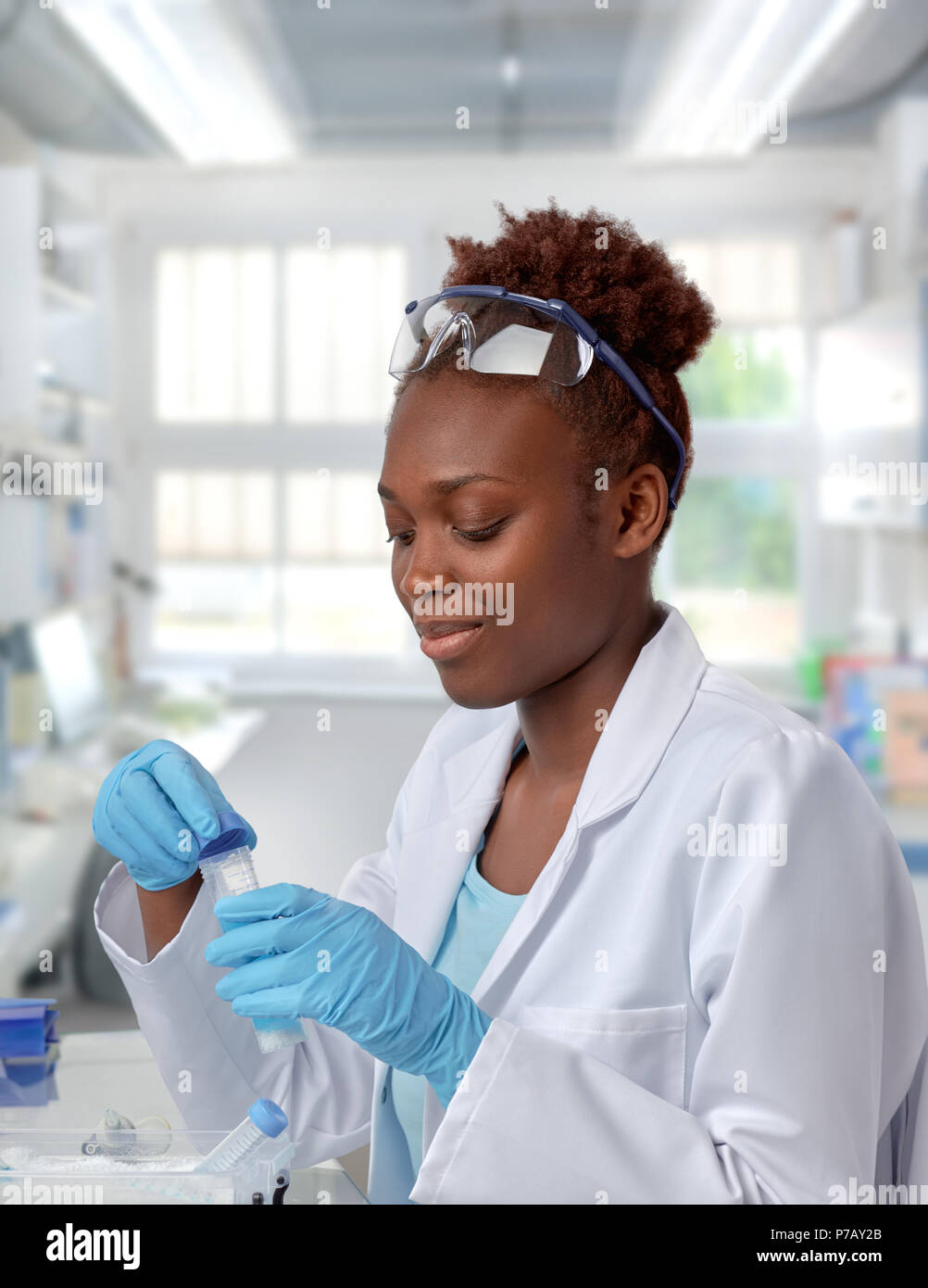 African-american scientist ou étudiant diplômé en sarrau et vêtements de protection travaillant avec des échantillons en laboratoire moderne Banque D'Images